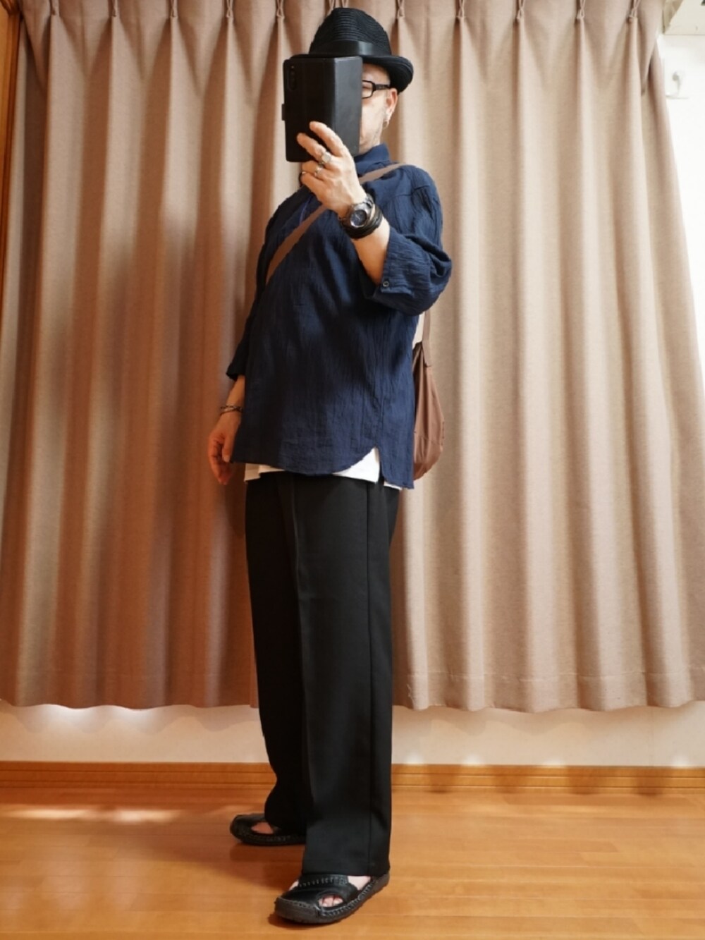 ブラック系のサンダル、ブラック系のパンツ、ホワイト系のタンクトップを着用したメンズの夏コーディネートの2枚目の写真