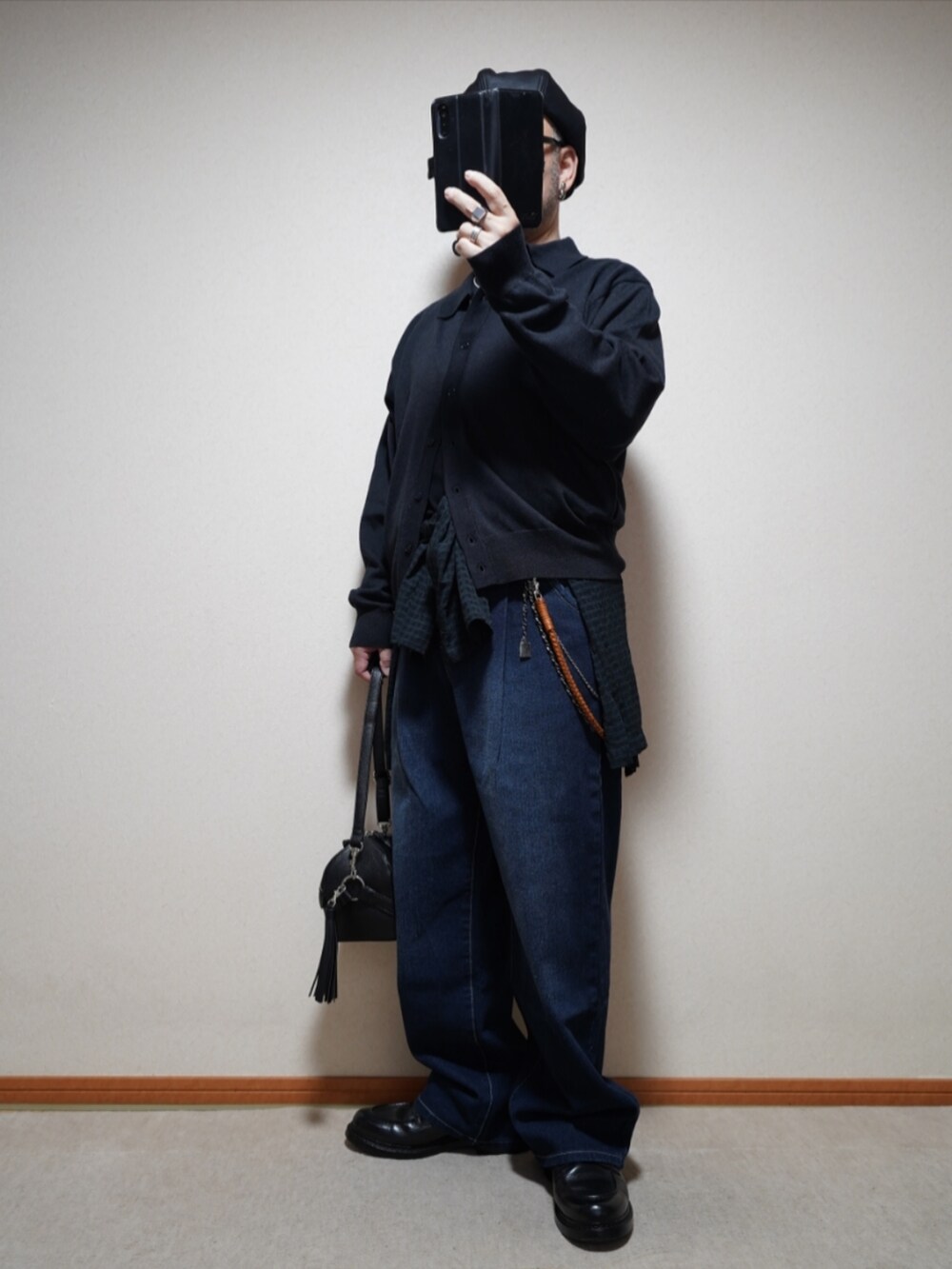 ブラック系のシューズ、ブルー系のデニムパンツ、ブラック系のショルダーバッグを着用したメンズの春コーディネートの2枚目の写真