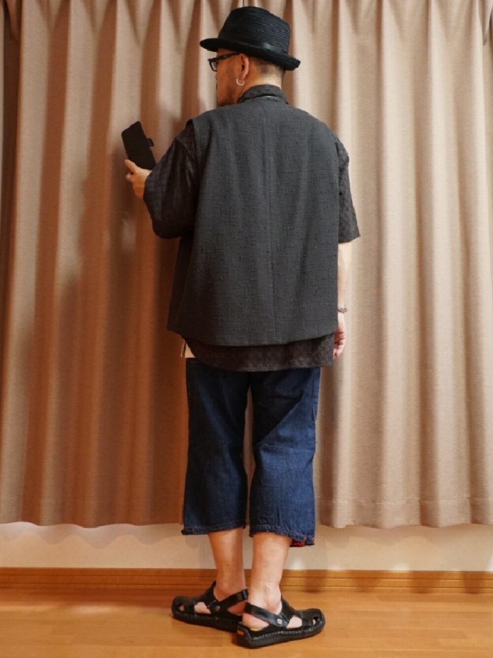 ブラック系のサンダル、ブルー系のデニムパンツ、ホワイト系のタンクトップを着用したメンズの夏コーディネートの3枚目の写真