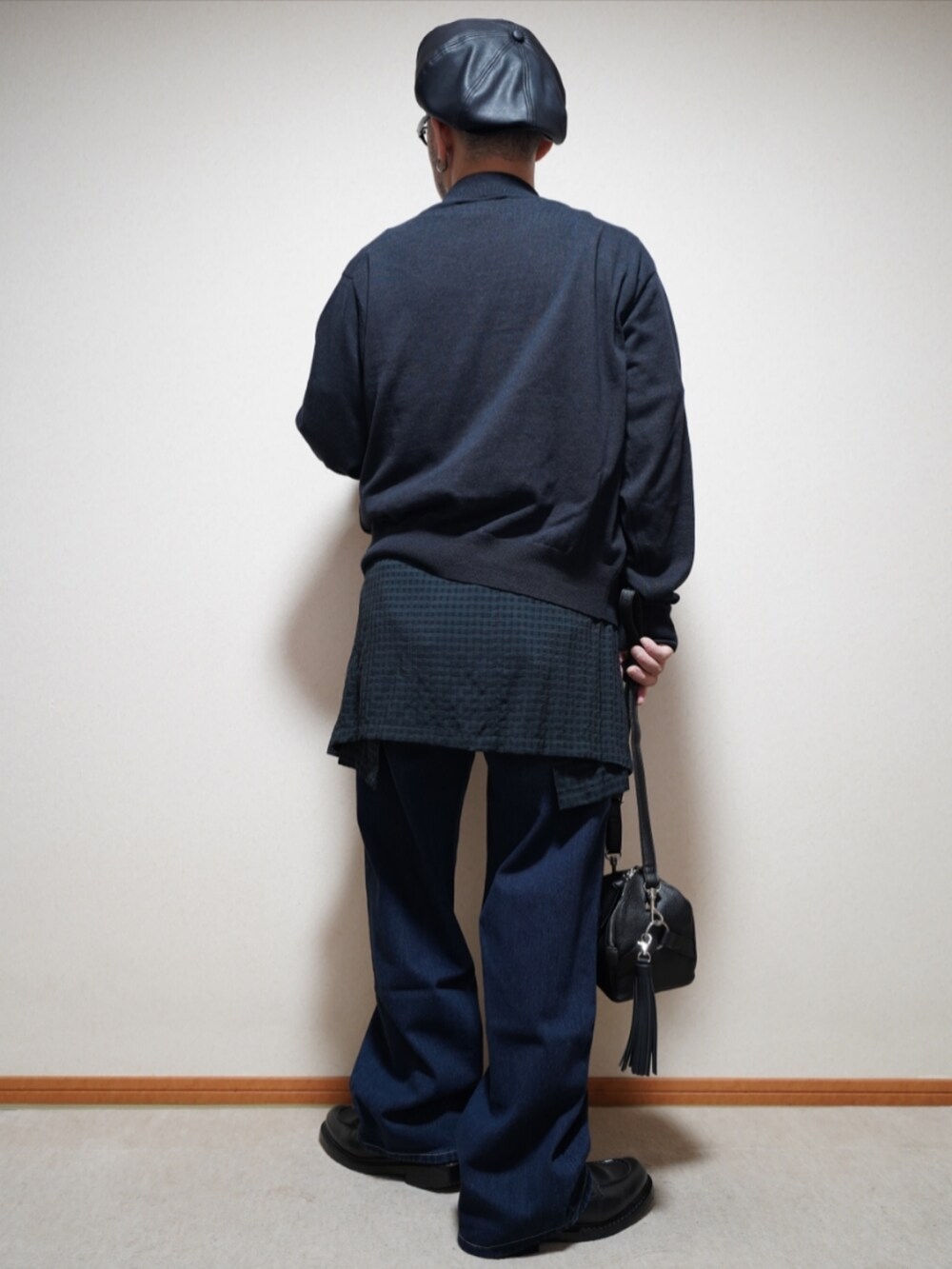 ブラック系のシューズ、ブルー系のデニムパンツ、ブラック系のショルダーバッグを着用したメンズの春コーディネートの4枚目の写真