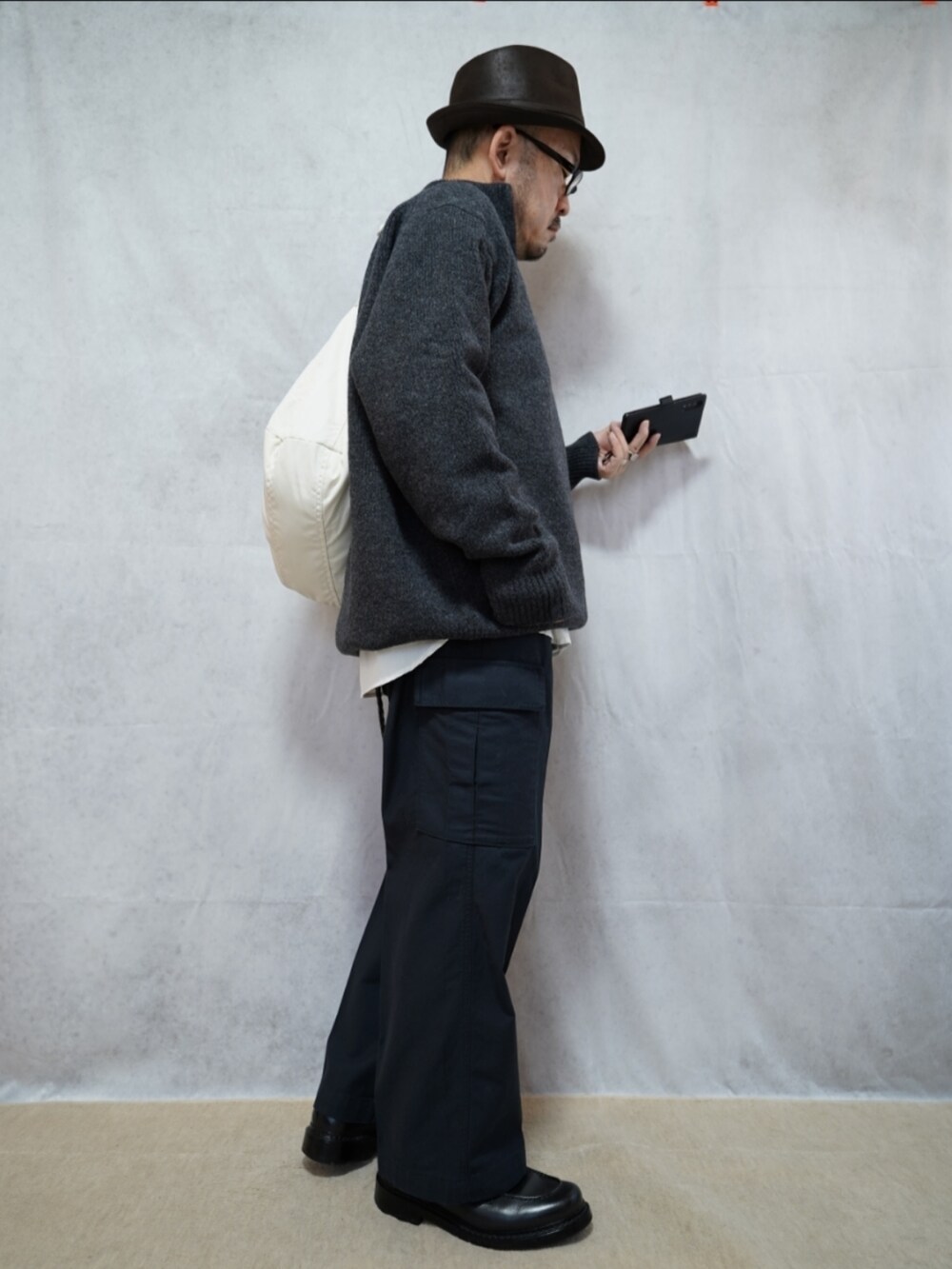 ブラック系のシューズ、グレー系のパンツ、グレー系のニット/セーターを着用したメンズの冬コーディネートの4枚目の写真