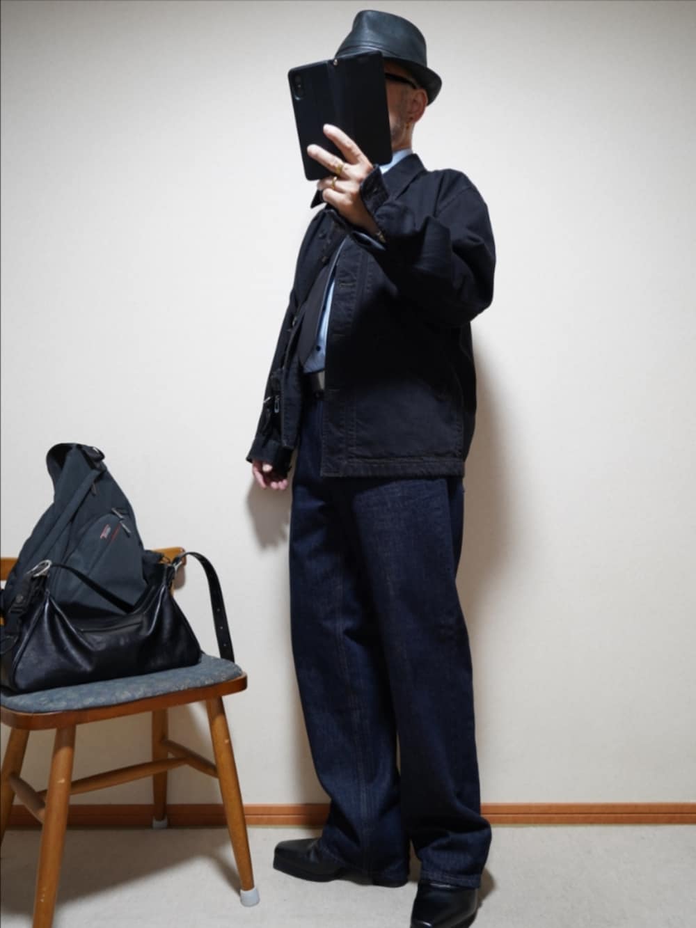 ブラック系のブーツ、ブルー系のデニムパンツ、ブラック系のデニムジャケットを着用したメンズの秋コーディネートの2枚目の写真