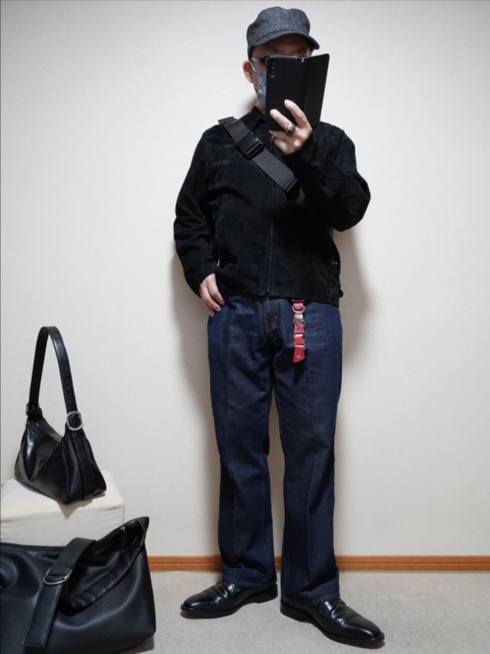 ブラック系のドレスシューズ、ブルー系のデニムパンツ、ブラック系のブルゾンを着用したメンズの春コーディネートの2枚目の写真