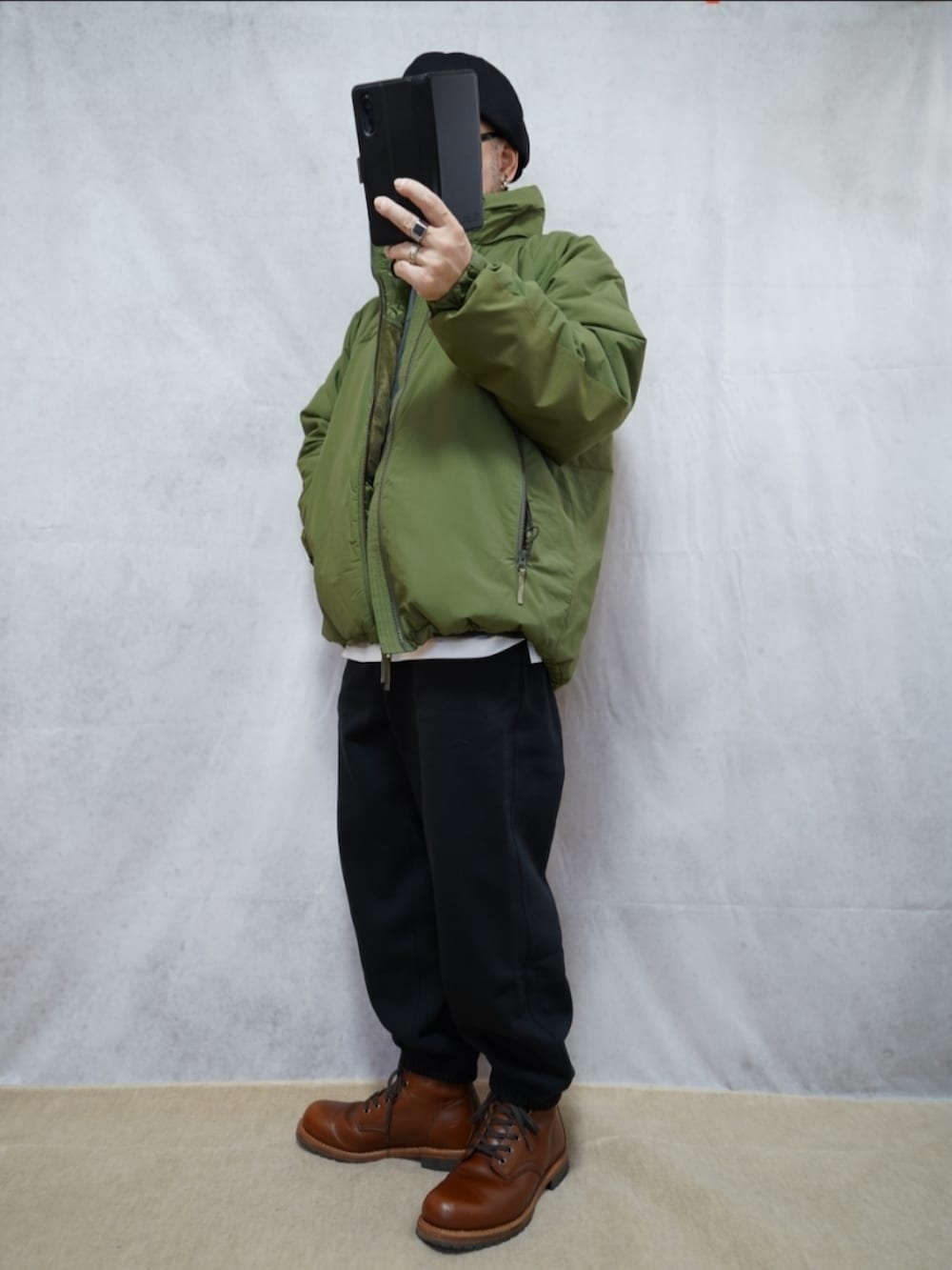 ブラウン系のブーツ、ブラック系のスウェットパンツ、グリーン系のダウンジャケット/コートを着用したメンズの冬コーディネートの2枚目の写真