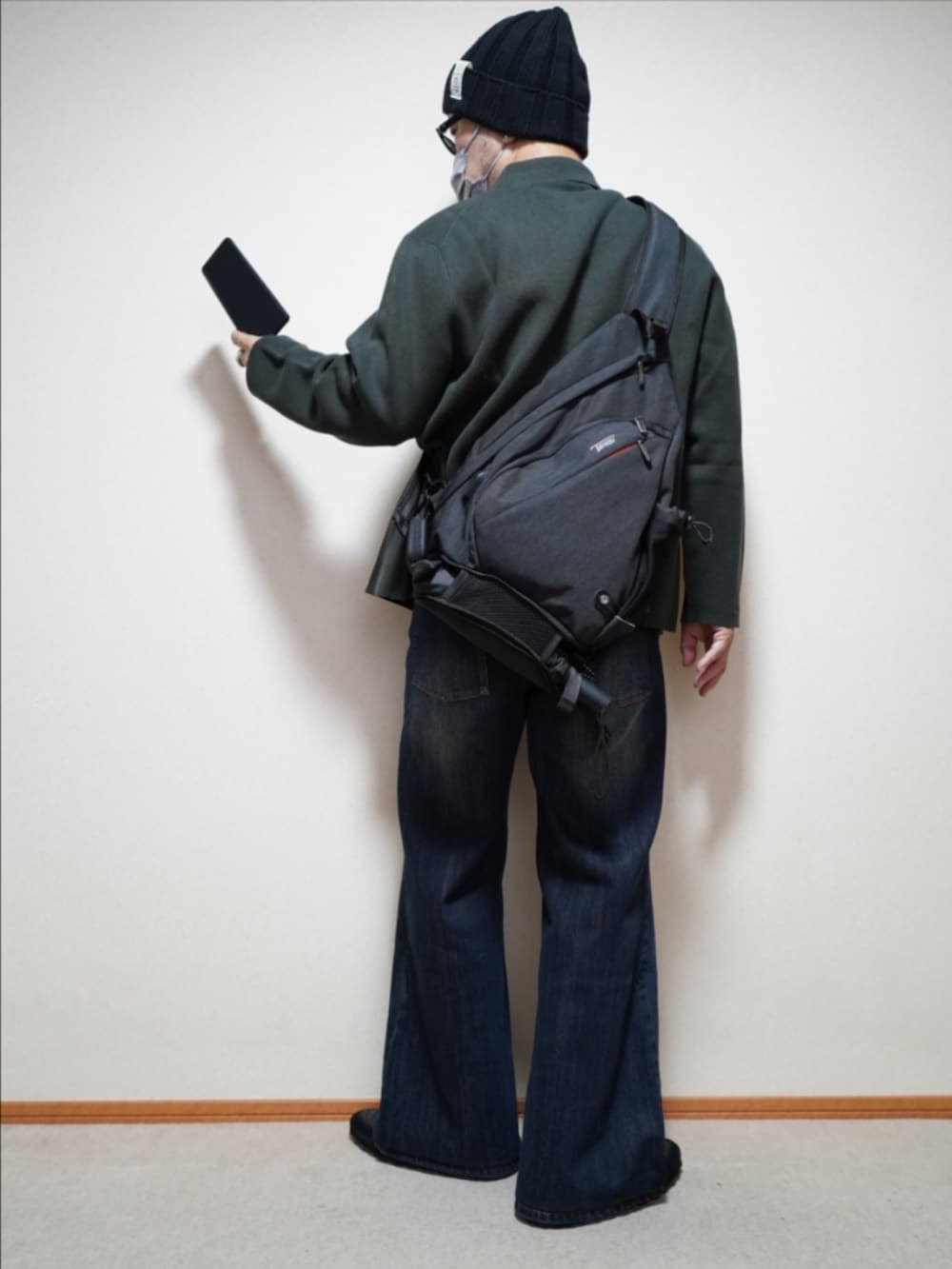 ブラック系のスニーカー、ブルー系のデニムパンツ、ブラック系のTシャツ/カットソーを着用したメンズの秋コーディネートの4枚目の写真