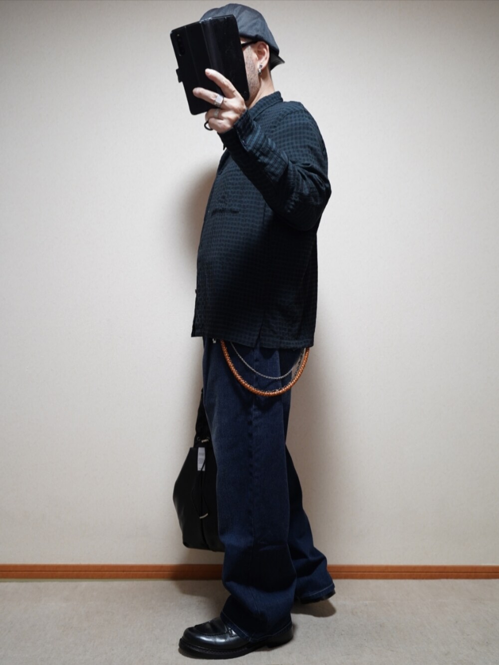 ブラック系のシューズ、ブルー系のデニムパンツ、ブラック系のTシャツ/カットソーを着用したメンズの春コーディネートの2枚目の写真