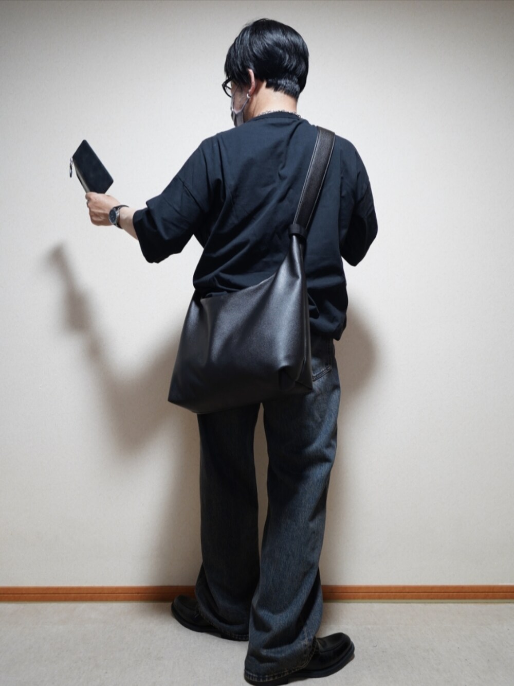 ブラック系のシューズ、ブルー系のデニムパンツ、ブラック系のTシャツ/カットソーを着用したメンズの夏コーディネートの3枚目の写真