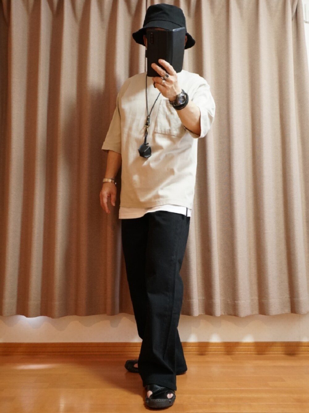 ブラック系のサンダル、グレー系のデニムパンツ、ホワイト系のタンクトップを着用したメンズの夏コーディネートの2枚目の写真