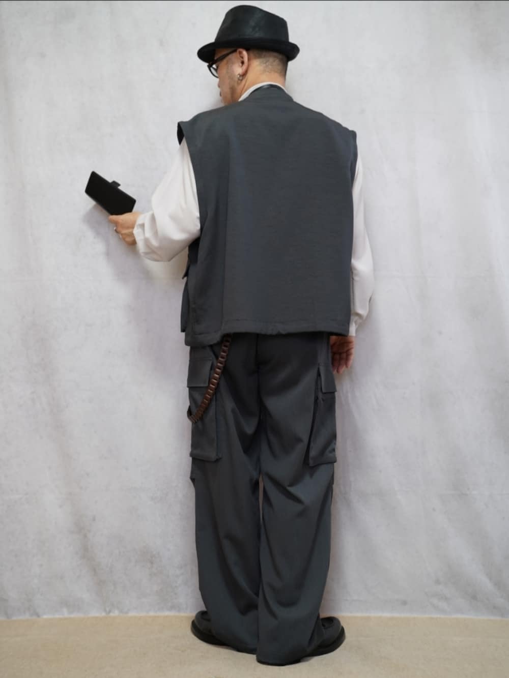 ブラック系のシューズ、グレー系のカーゴパンツ、ブラック系のショルダーバッグを着用したメンズの春コーディネートの3枚目の写真