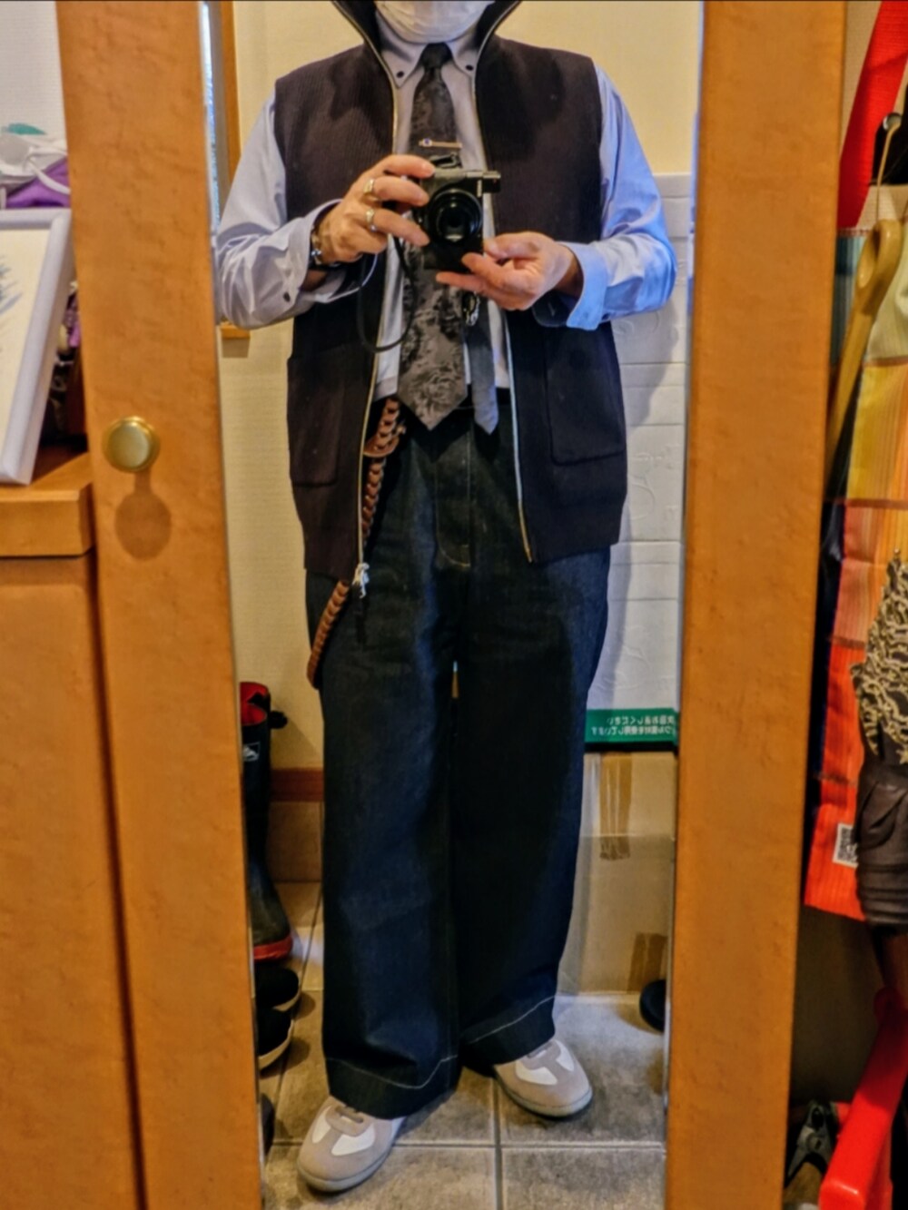 ホワイト系のスニーカー、ブルー系のデニムパンツ、ブラック系のネクタイを着用したメンズの春コーディネートの3枚目の写真