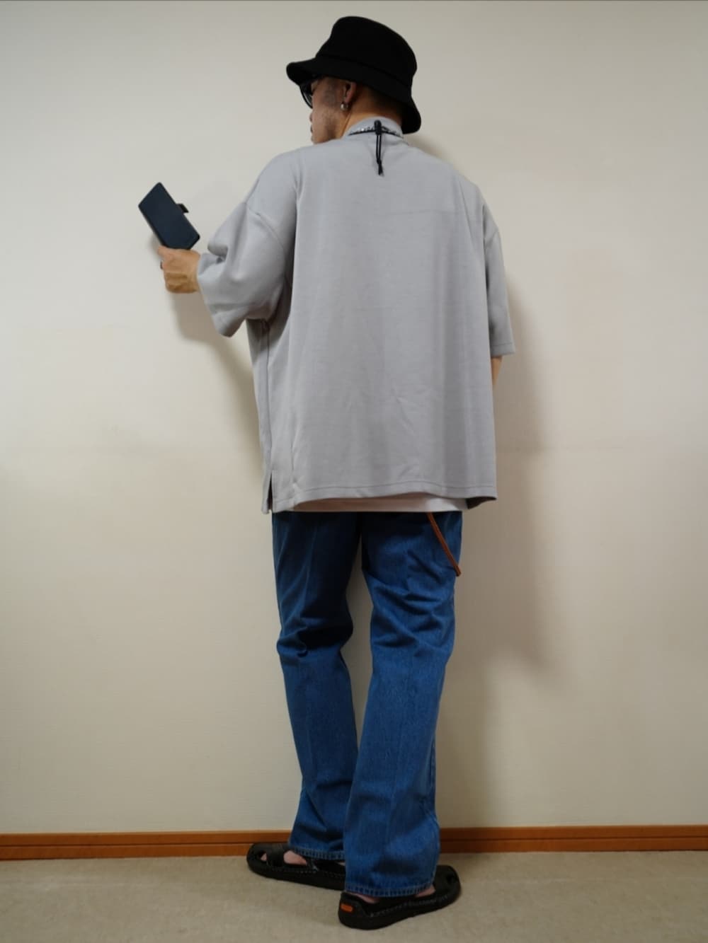 ブラック系のサンダル、ブルー系のデニムパンツ、ホワイト系のタンクトップを着用したメンズの夏コーディネートの3枚目の写真