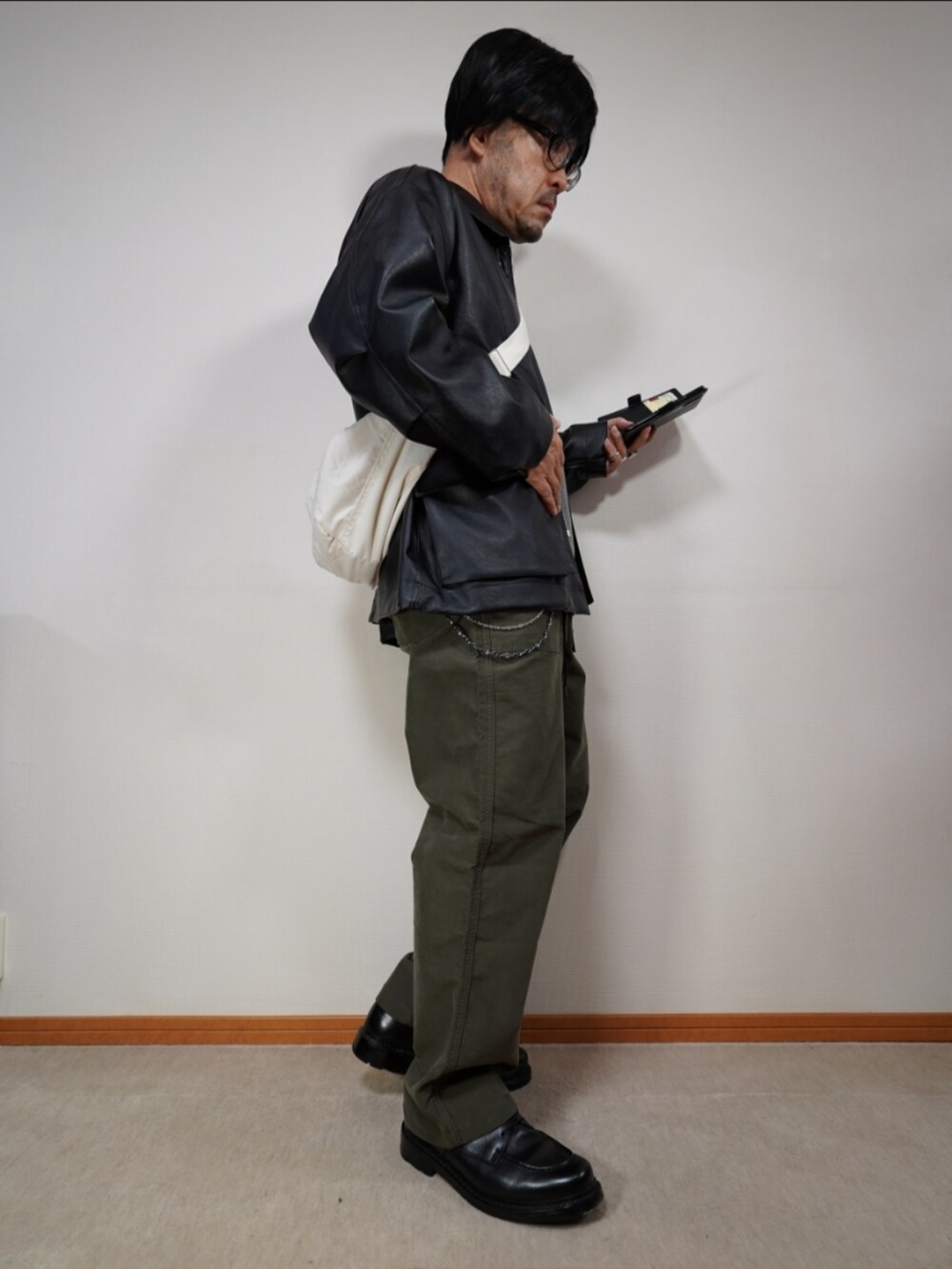 ブラック系のシューズ、グリーン系のパンツ、グレー系のニット/セーターを着用したメンズの秋コーディネートの4枚目の写真