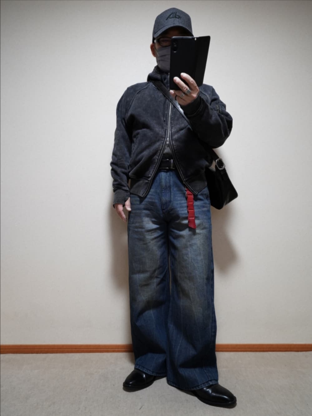 ブルー系のデニムパンツ、ブラック系のパーカー、ブラック系のショルダーバッグを着用したメンズの冬コーディネートの2枚目の写真