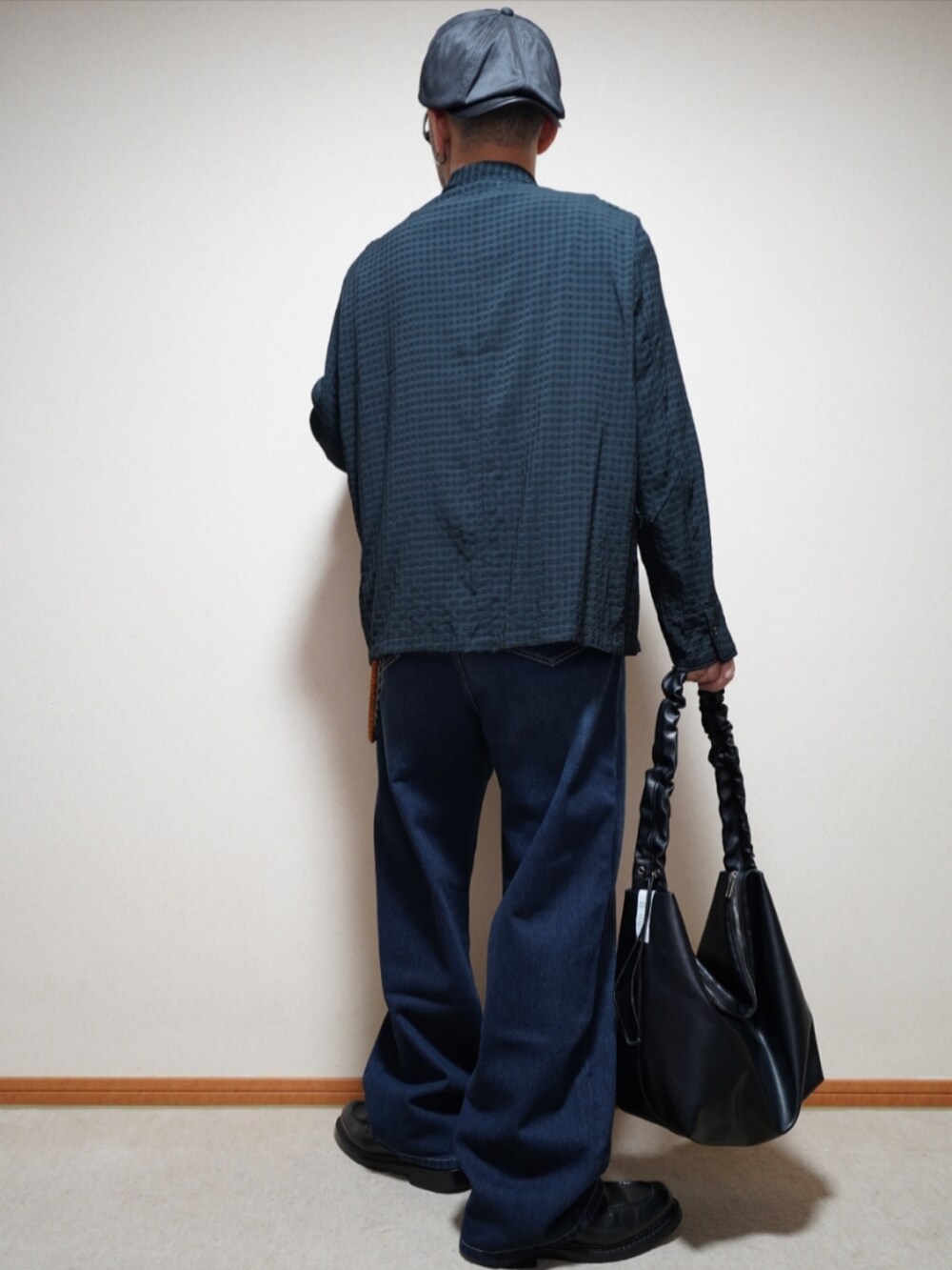 ブラック系のシューズ、ブルー系のデニムパンツ、ブラック系のTシャツ/カットソーを着用したメンズの春コーディネートの4枚目の写真