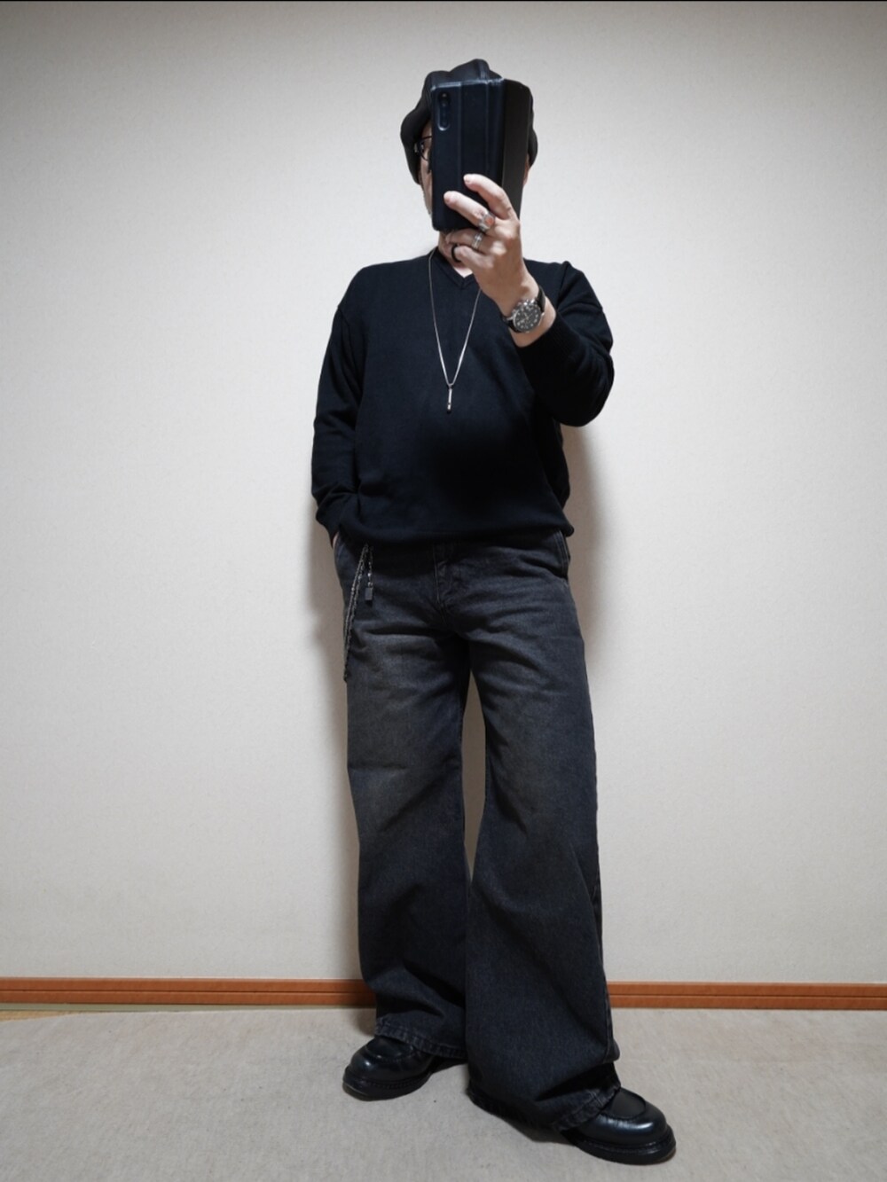 ブラック系のシューズ、ブラック系のデニムパンツ、ブラック系のニット/セーターを着用したメンズの春コーディネートの2枚目の写真