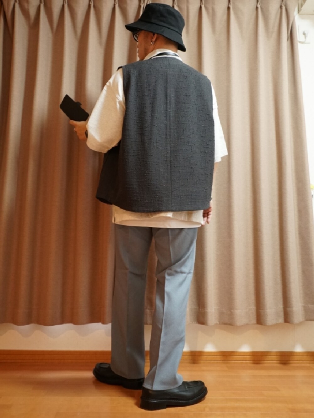 ブルー系のパンツ、ホワイト系のタンクトップ、ブラック系のショルダーバッグを着用したメンズの夏コーディネートの3枚目の写真