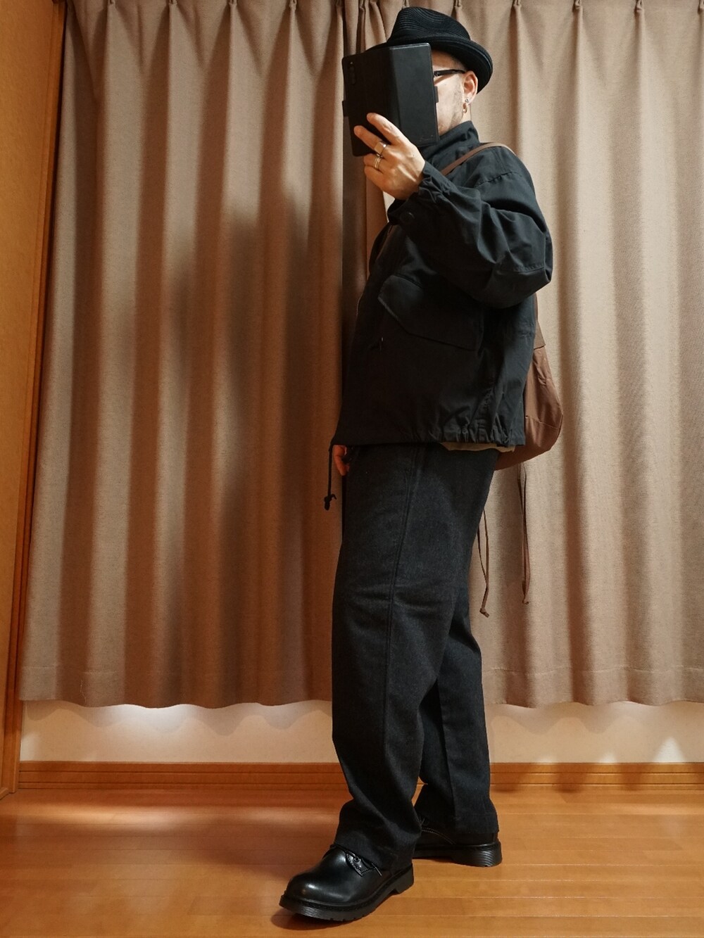 ブラック系のシューズ、グレー系のパンツ、ブラック系のモッズコートを着用したメンズの秋コーディネートの2枚目の写真