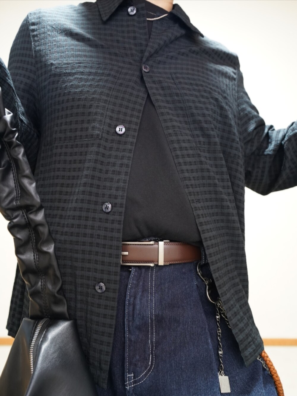 ブラック系のシューズ、ブルー系のデニムパンツ、ブラック系のTシャツ/カットソーを着用したメンズの春コーディネートの3枚目の写真