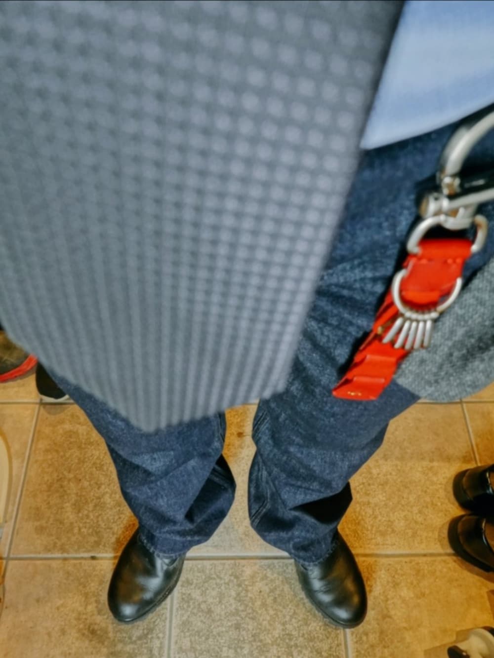 ブルー系のデニムパンツ、グレー系のテーラードジャケット、ブラック系のブーツを着用したメンズの春コーディネートの3枚目の写真