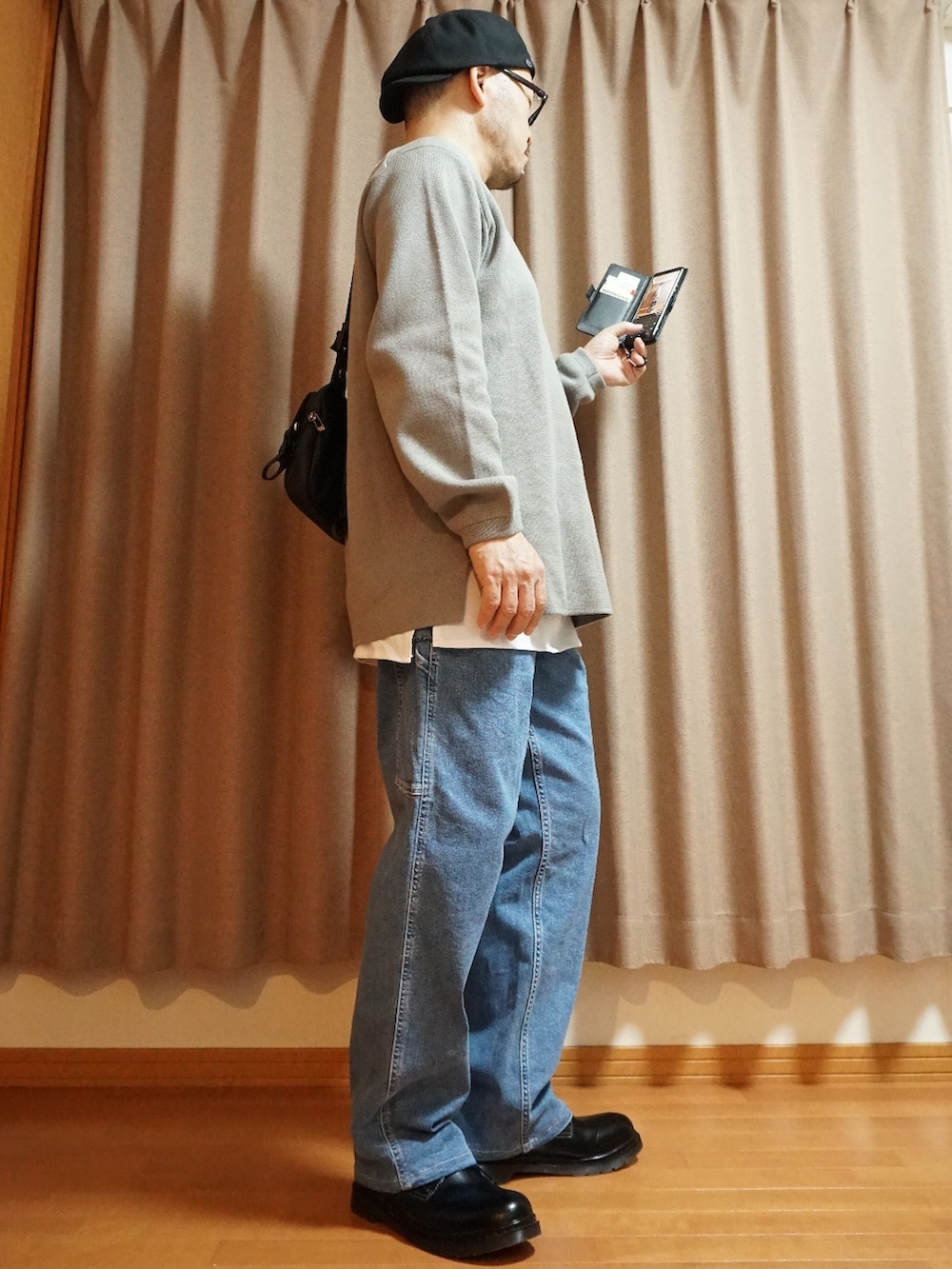 ブラック系のシューズ、ブルー系のデニムパンツ、グレー系のニット/セーターを着用したメンズの夏コーディネートの4枚目の写真