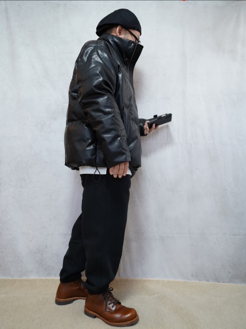 ブラウン系のブーツ、ブラック系のスウェットパンツ、ブラック系のダウンジャケット/コートを着用したメンズの冬コーディネートの4枚目の写真