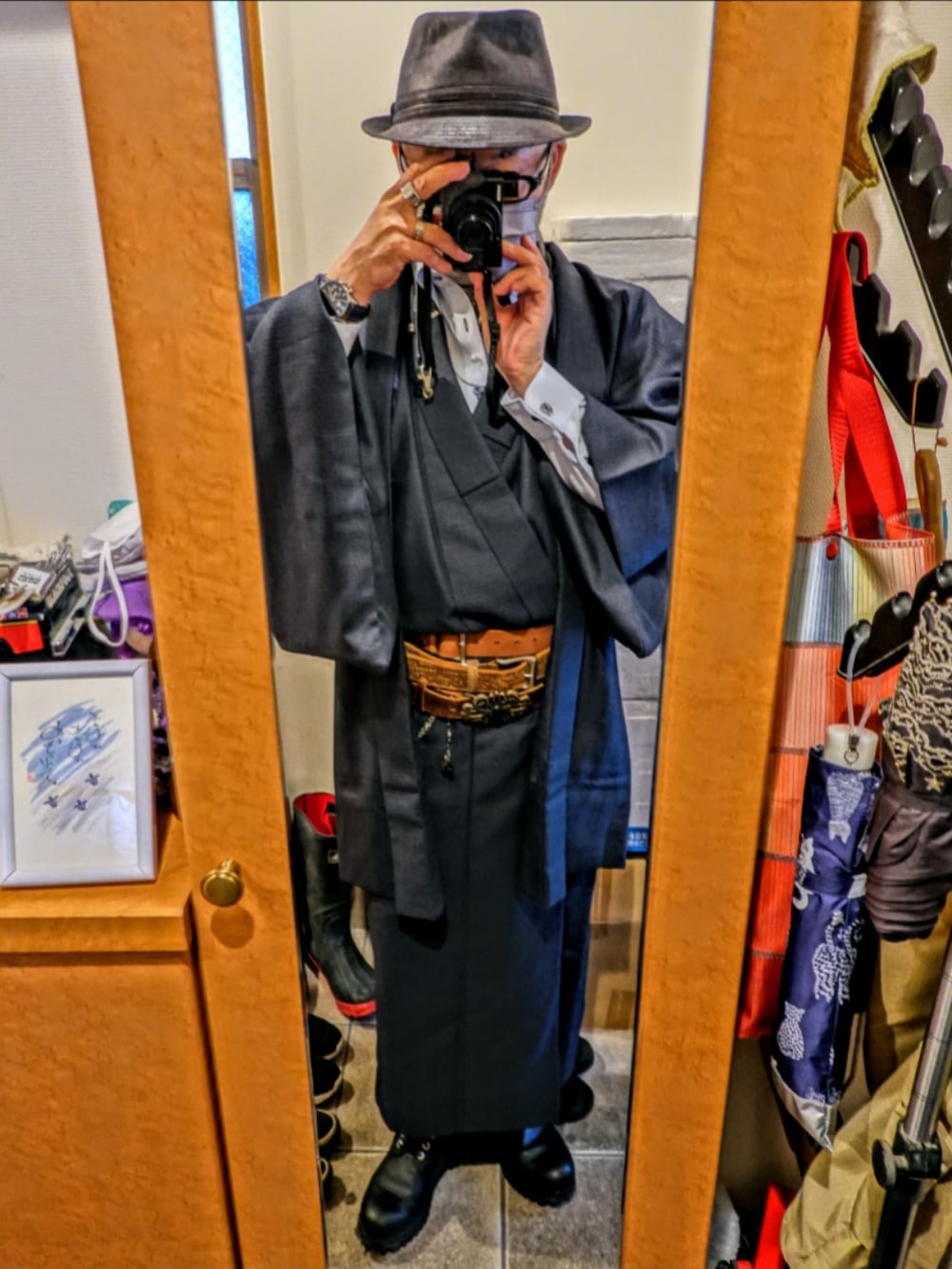 ブラック系のブーツ、ブルー系のネクタイ、シルバー系のファッション雑貨を着用したメンズの冬コーディネートの2枚目の写真