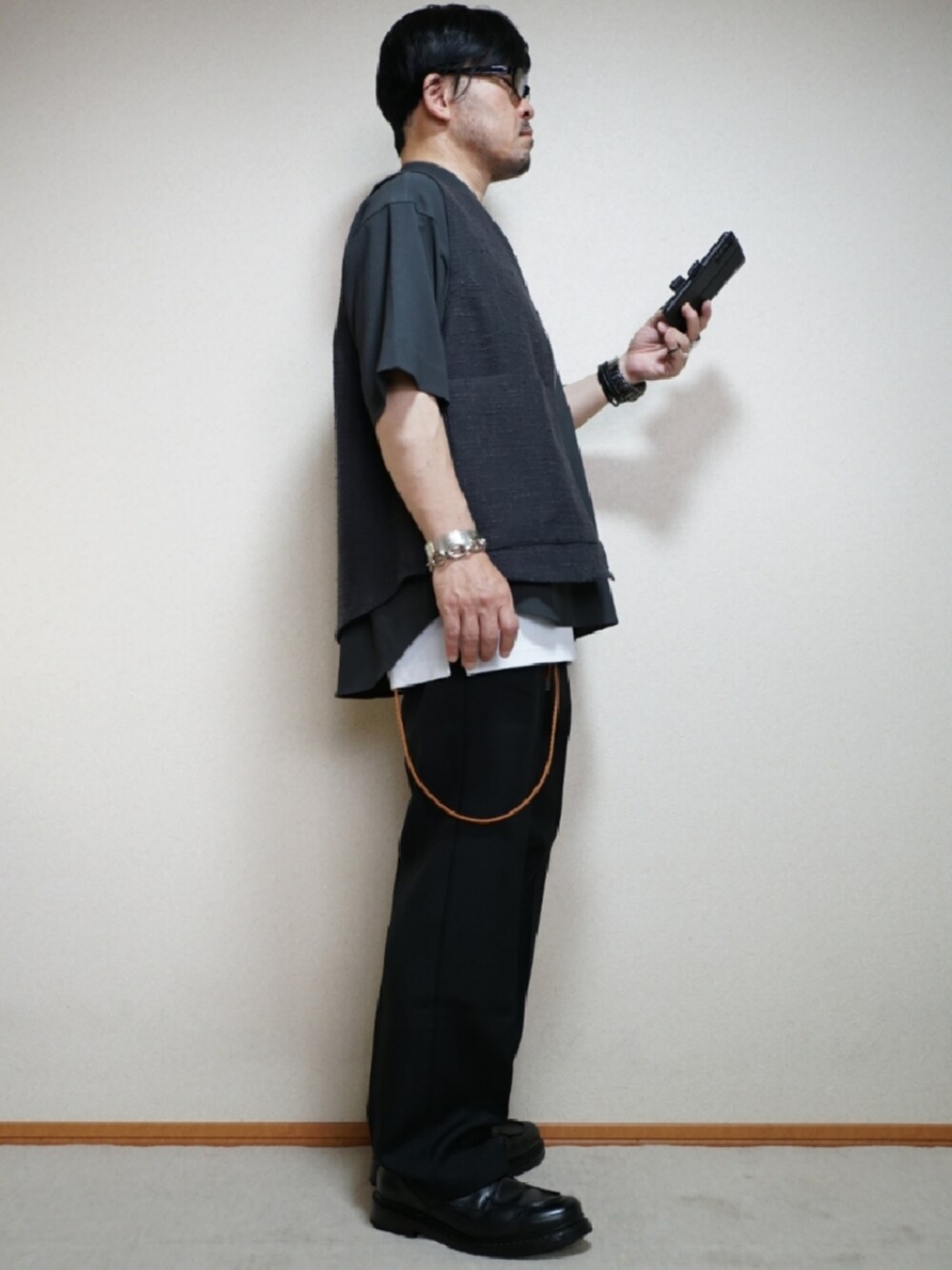 ブラック系のシューズ、ブラック系のパンツ、ホワイト系のタンクトップを着用したメンズの夏コーディネートの5枚目の写真