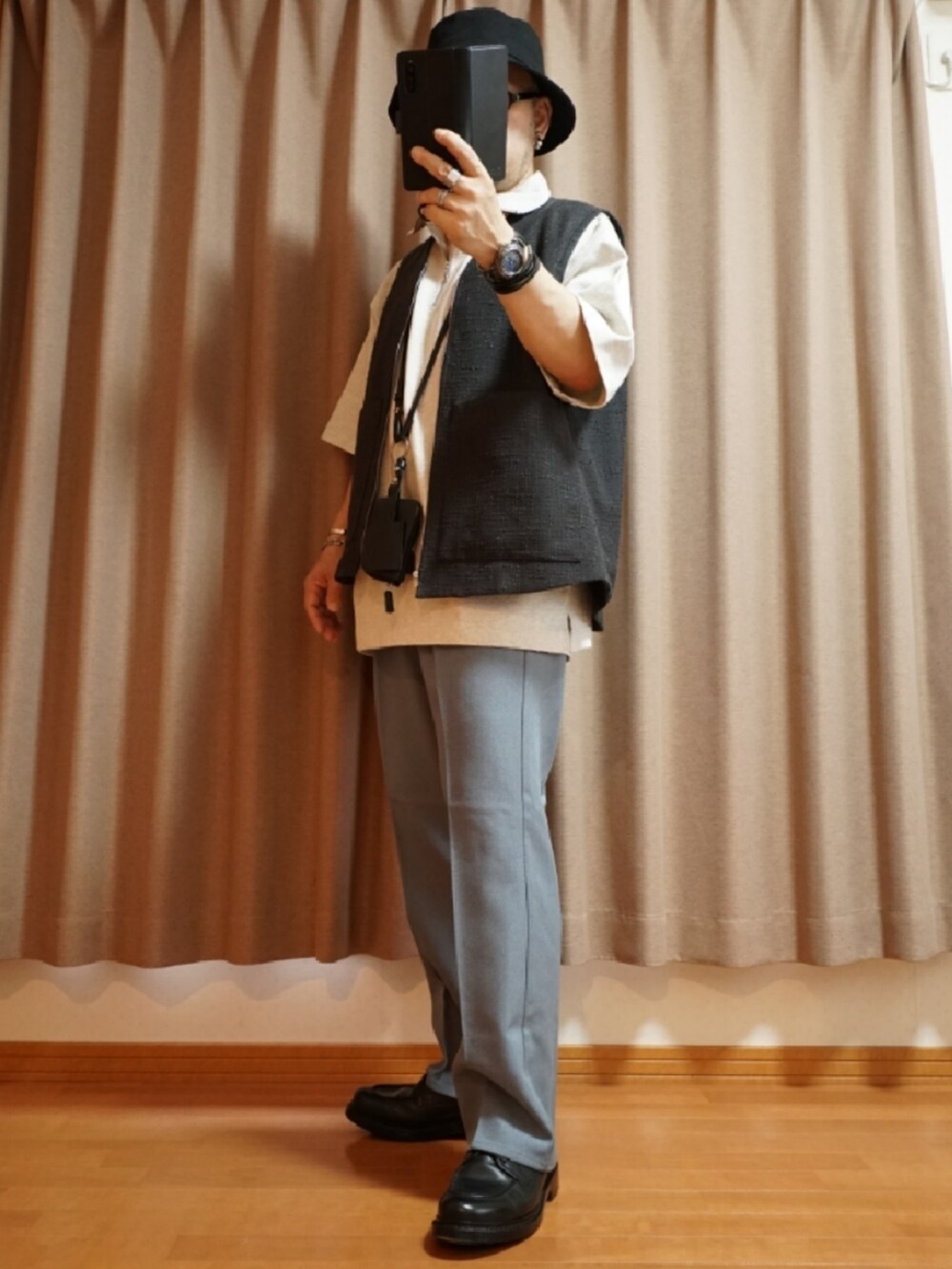 ブルー系のパンツ、ホワイト系のタンクトップ、ブラック系のショルダーバッグを着用したメンズの夏コーディネートの2枚目の写真