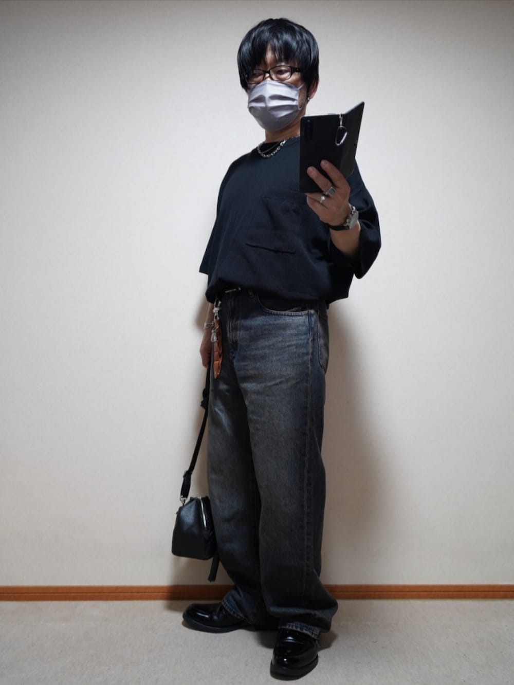 ブラック系のシューズ、ブルー系のデニムパンツ、ブラック系のショルダーバッグを着用したメンズの夏コーディネートの2枚目の写真