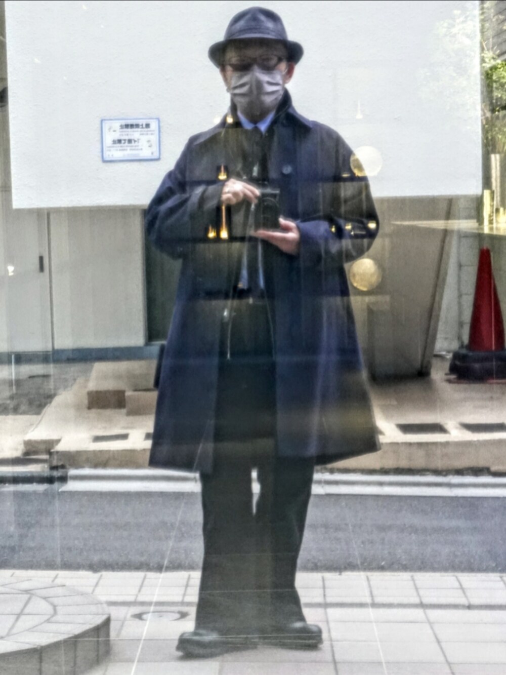 グレー系のデニムパンツ、グレー系のブルゾン、ブルー系のステンカラーコートを着用したメンズの春コーディネートの3枚目の写真