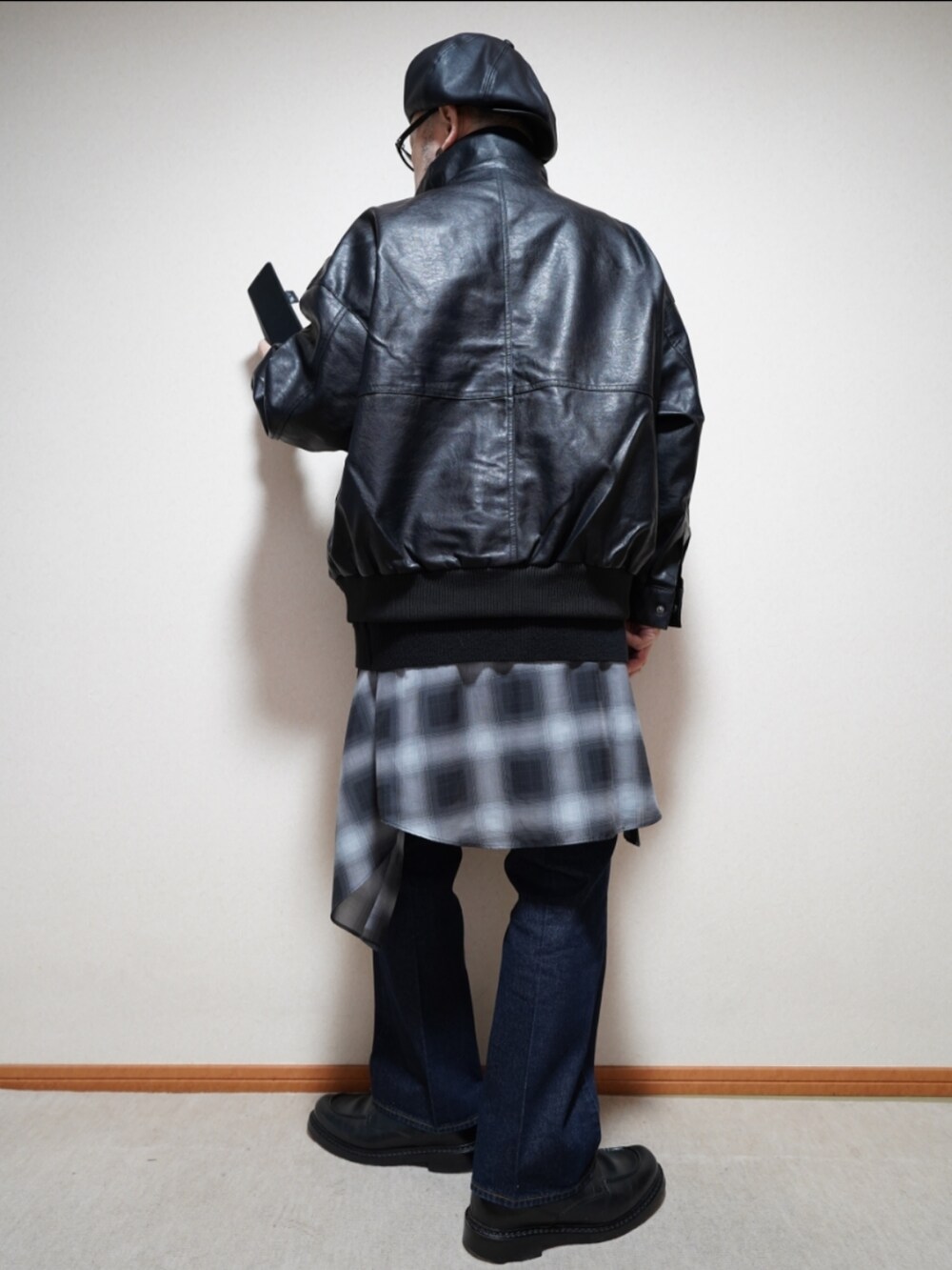 ブラック系のシューズ、ブルー系のデニムパンツ、ブラック系のシャツ/ブラウスを着用したメンズの冬コーディネートの4枚目の写真