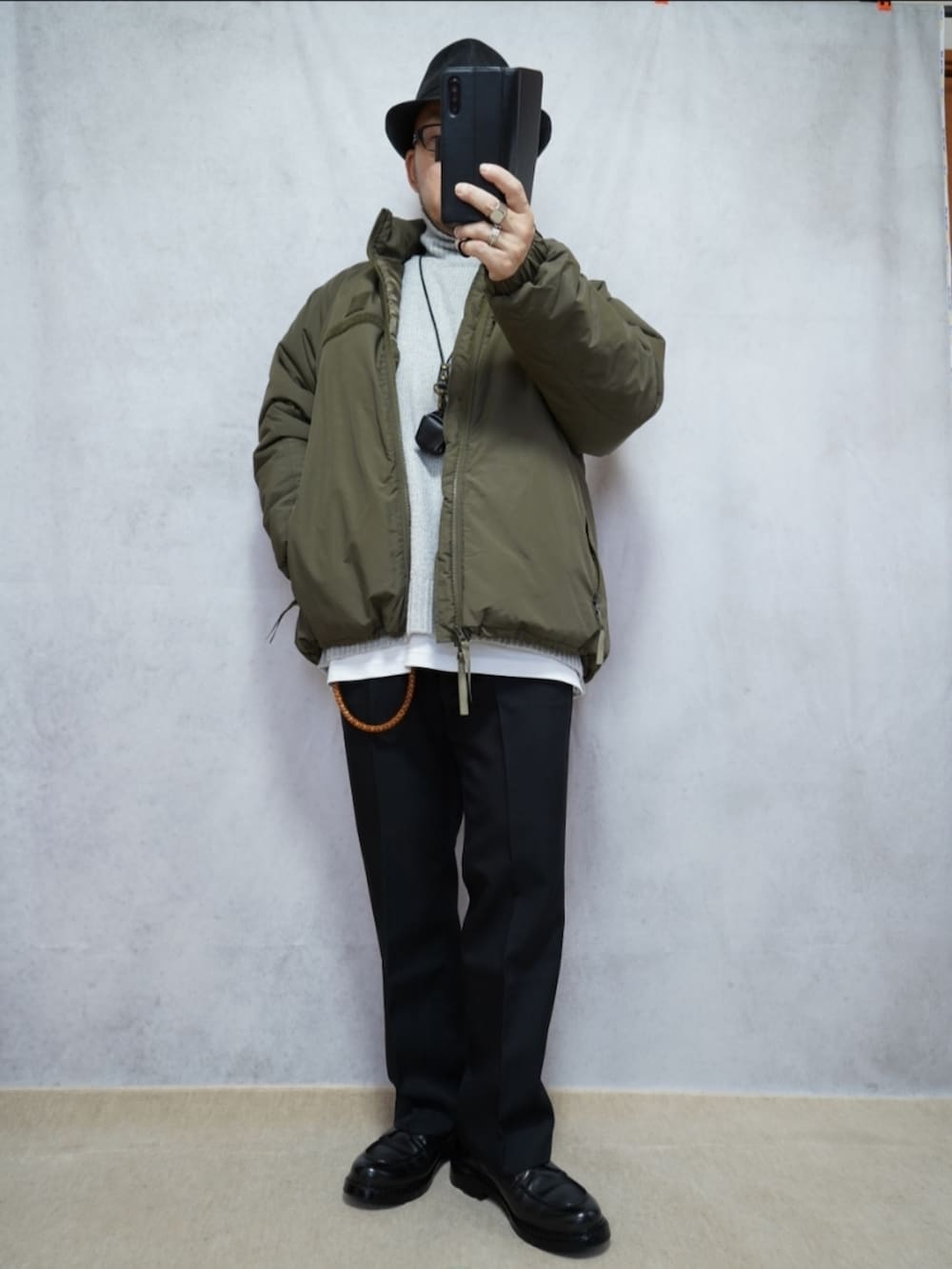 ブラック系のシューズ、ブルー系のデニムパンツ、グリーン系のダウンジャケット/コートを着用したメンズの冬コーディネートの3枚目の写真