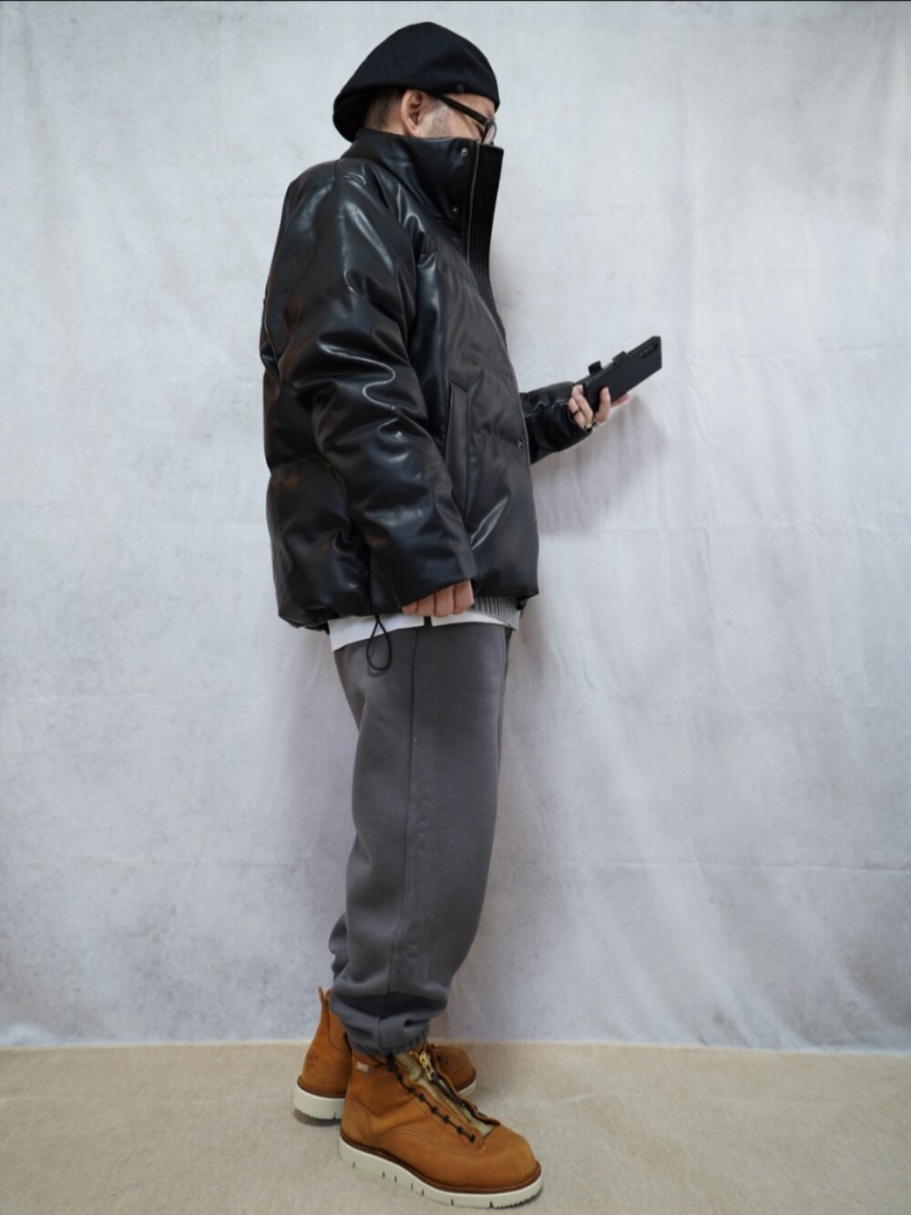 ブラウン系のブーツ、グレー系のスウェットパンツ、グレー系のニット/セーターを着用したメンズの冬コーディネートの3枚目の写真