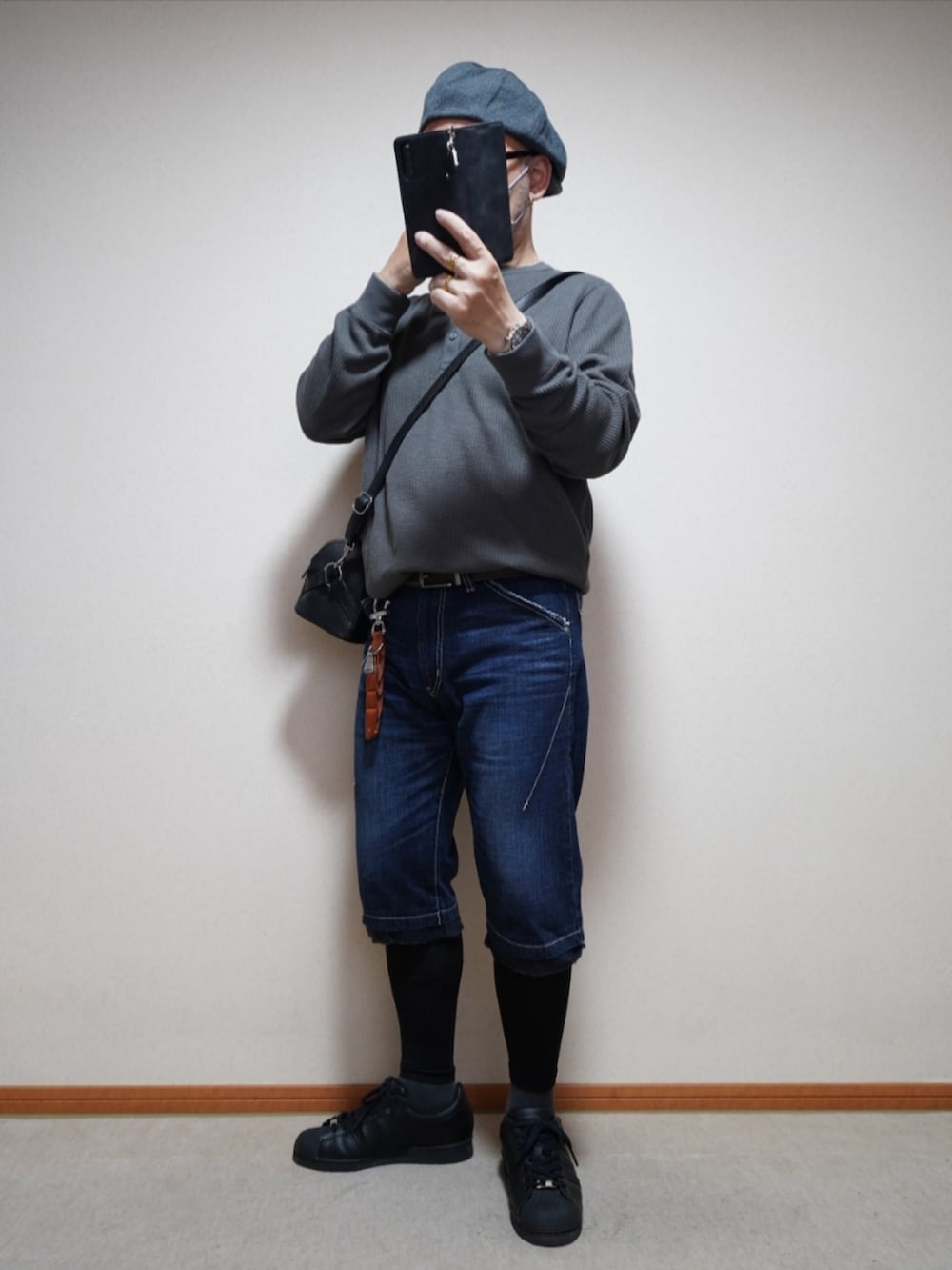 ブラック系のスニーカー、ブルー系のパンツ、グレー系のTシャツ/カットソーを着用したメンズの夏コーディネートの2枚目の写真