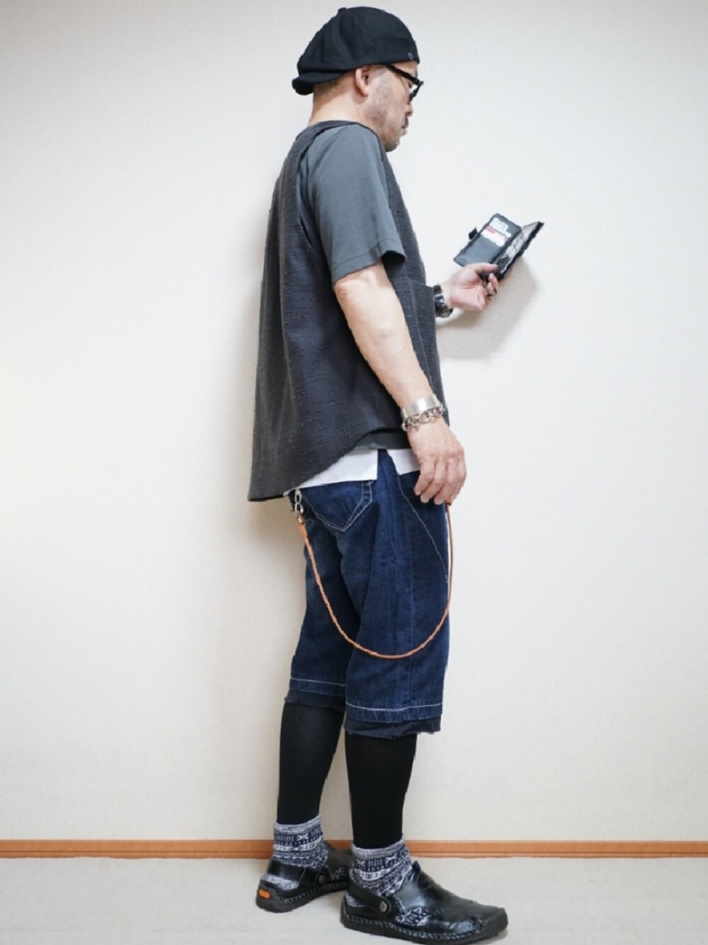 ブラック系のサンダル、ブルー系のパンツ、ホワイト系のタンクトップを着用したメンズの夏コーディネートの4枚目の写真