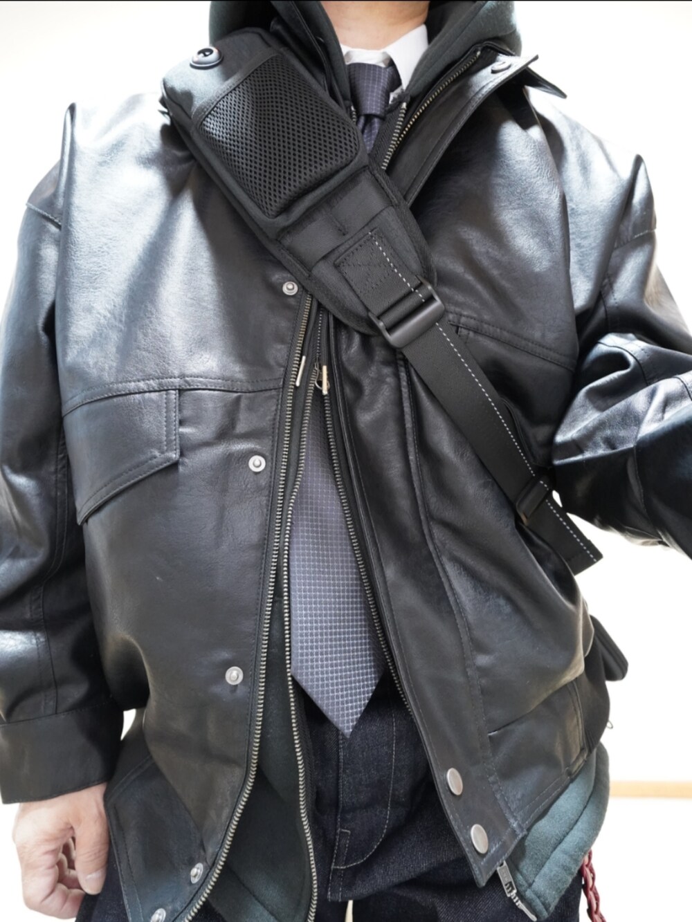 ブラック系のシューズ、ブルー系のデニムパンツ、ブラック系のパーカーを着用したメンズの冬コーディネートの3枚目の写真