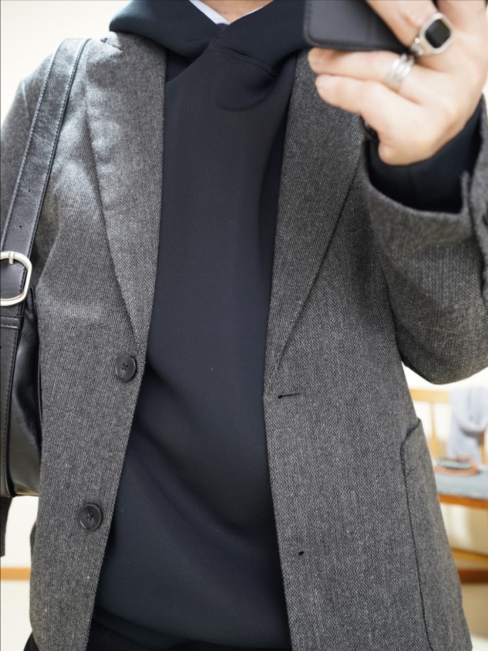 ブラック系のブーツ、ブラック系のデニムパンツ、ブラック系のショルダーバッグを着用したメンズの春コーディネートの3枚目の写真