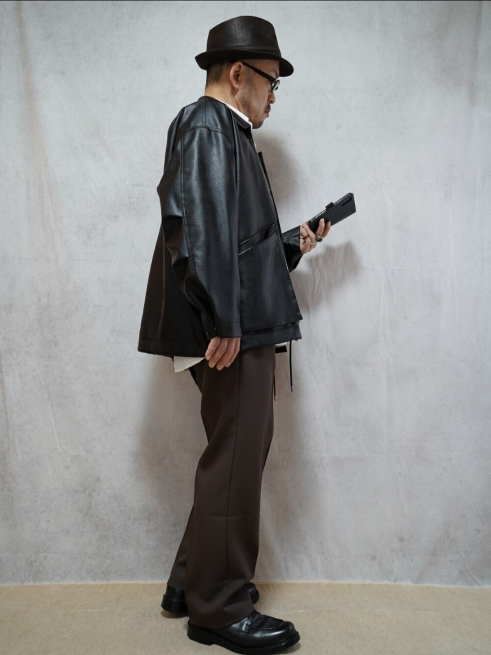 ブラック系のシューズ、ブラウン系のパンツ、ホワイト系のシャツ/ブラウスを着用したメンズの冬コーディネートの4枚目の写真