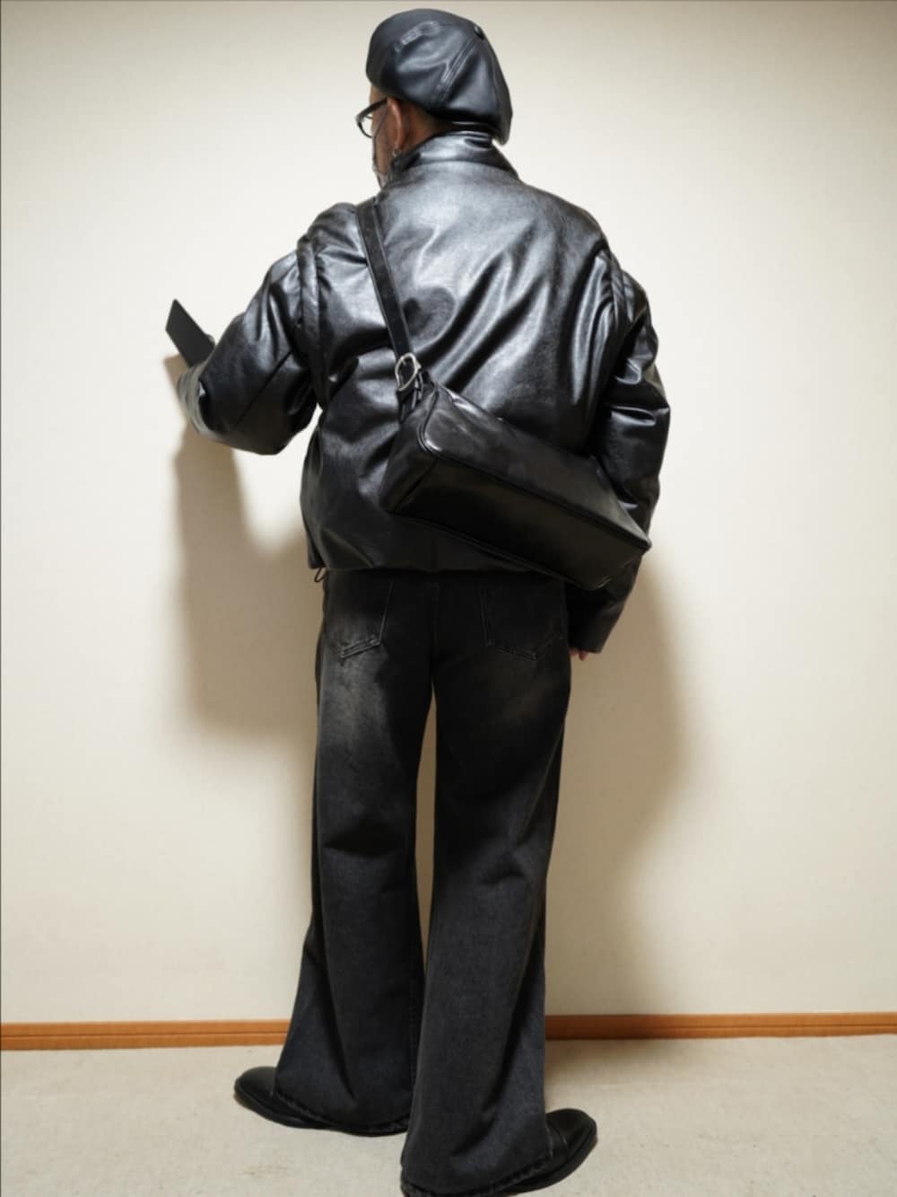 ブラック系のドレスシューズ、ブラック系のデニムパンツ、ブラック系のダウンジャケット/コートを着用したメンズの冬コーディネートの4枚目の写真