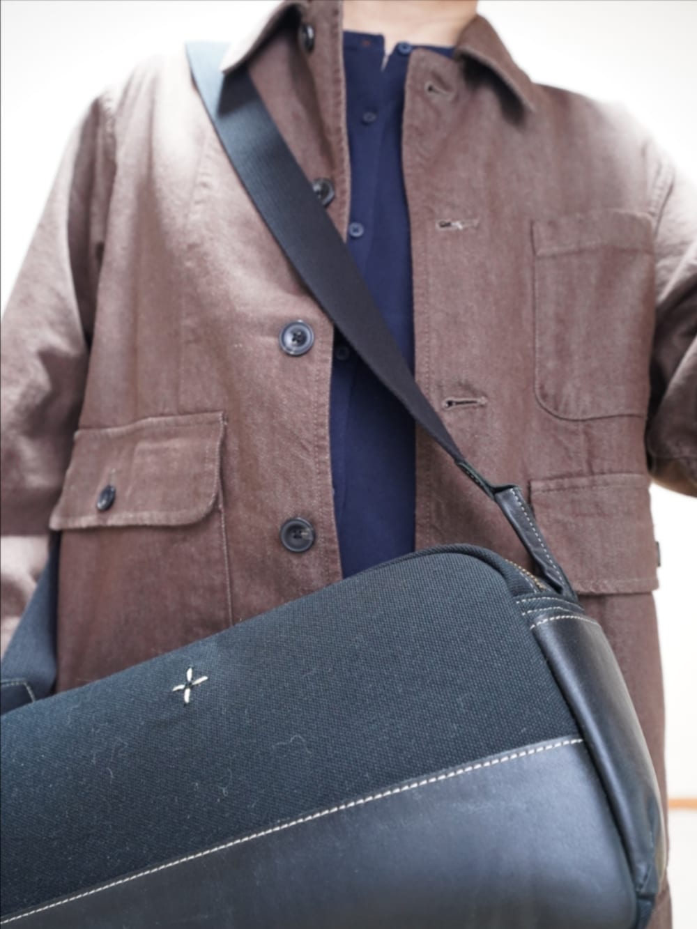 ブラック系のドレスシューズ、ブラック系のデニムパンツ、ブルー系のカーディガン/ボレロを着用したメンズの秋コーディネートの4枚目の写真