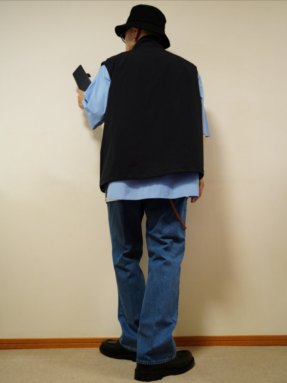 ブラック系のシューズ、ブルー系のデニムパンツ、ホワイト系のタンクトップを着用したメンズの夏コーディネートの3枚目の写真