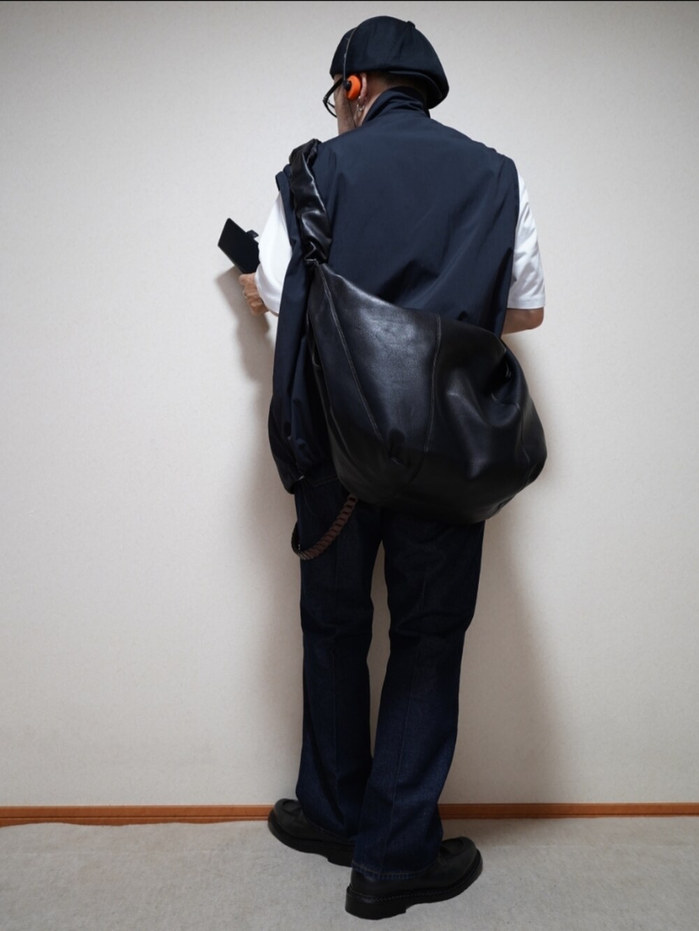 ブラック系のシューズ、ブルー系のデニムパンツ、ホワイト系のTシャツ/カットソーを着用したメンズの秋コーディネートの4枚目の写真