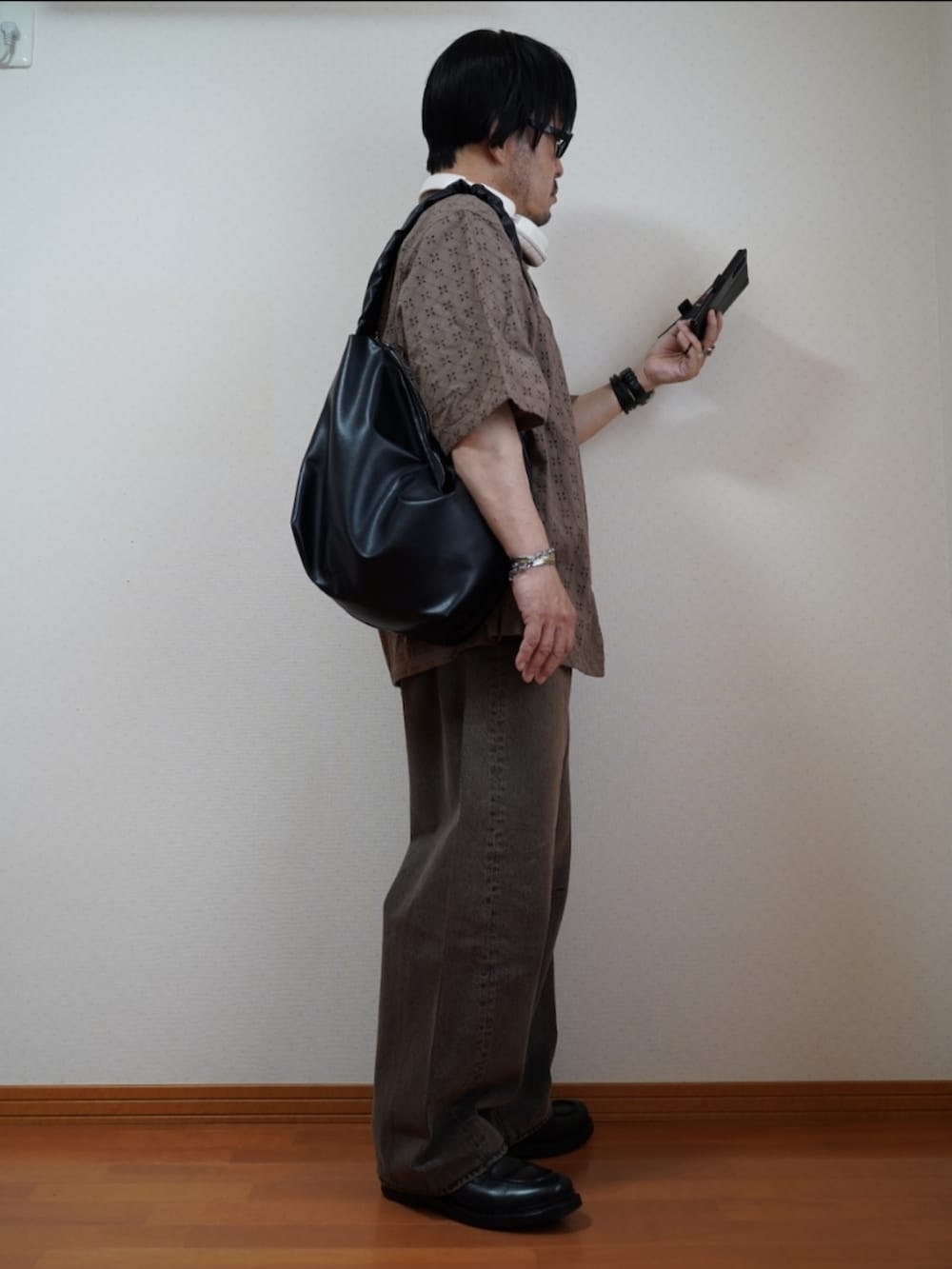 ブラック系のシューズ、ブラウン系のデニムパンツ、ブラック系のTシャツ/カットソーを着用したメンズの夏コーディネートの3枚目の写真