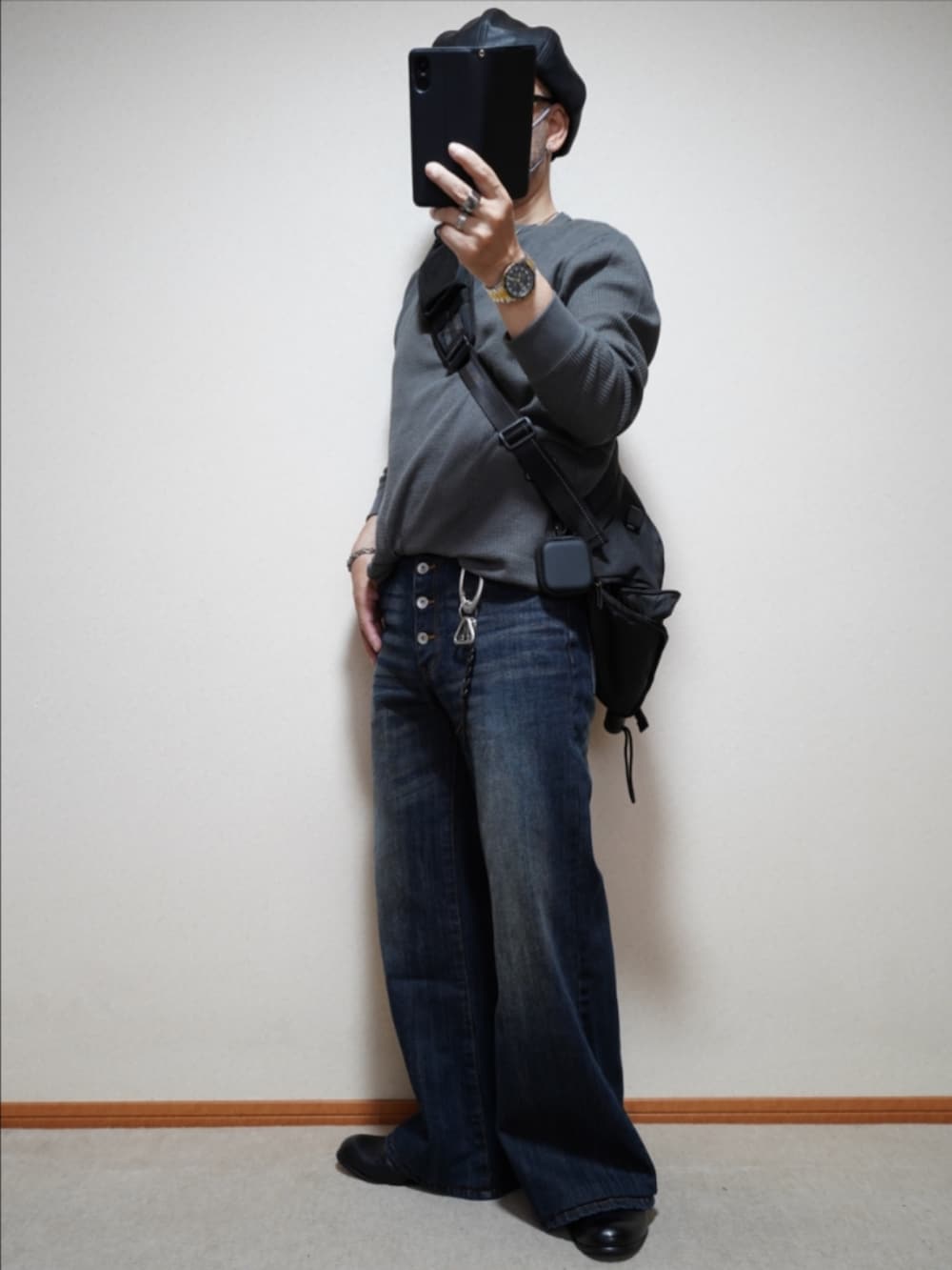 ブルー系のデニムパンツ、グレー系のTシャツ/カットソー、ブラック系のバッグを着用したメンズの秋コーディネートの2枚目の写真