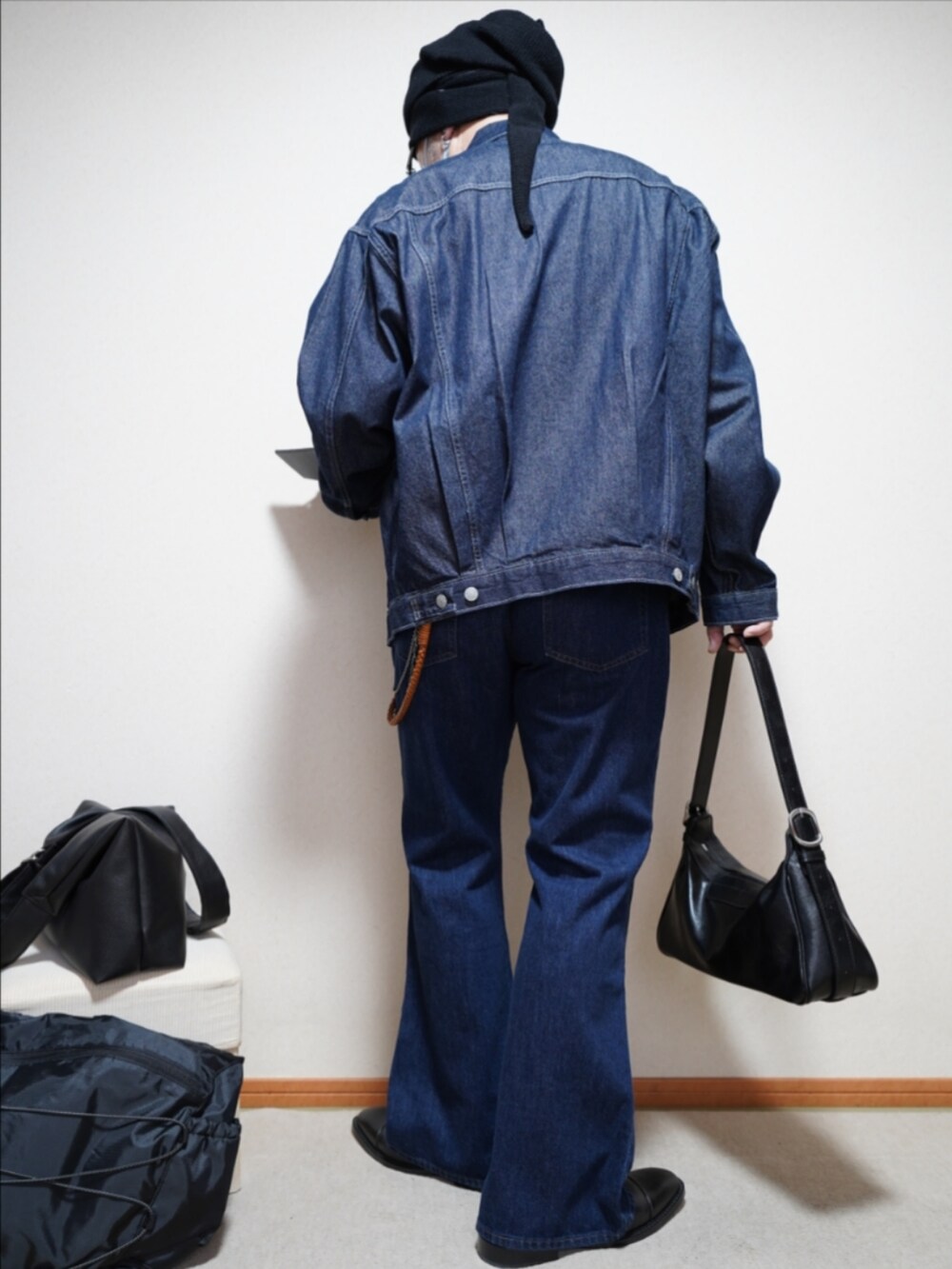 ブラック系のドレスシューズ、ブルー系のデニムパンツ、ブラウン系のカーディガン/ボレロを着用したメンズの春コーディネートの4枚目の写真