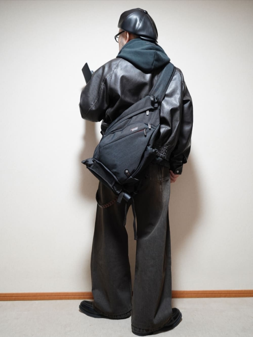 ブラック系のシューズ、ブラック系のデニムパンツ、ブラック系のパーカーを着用したメンズの春コーディネートの3枚目の写真
