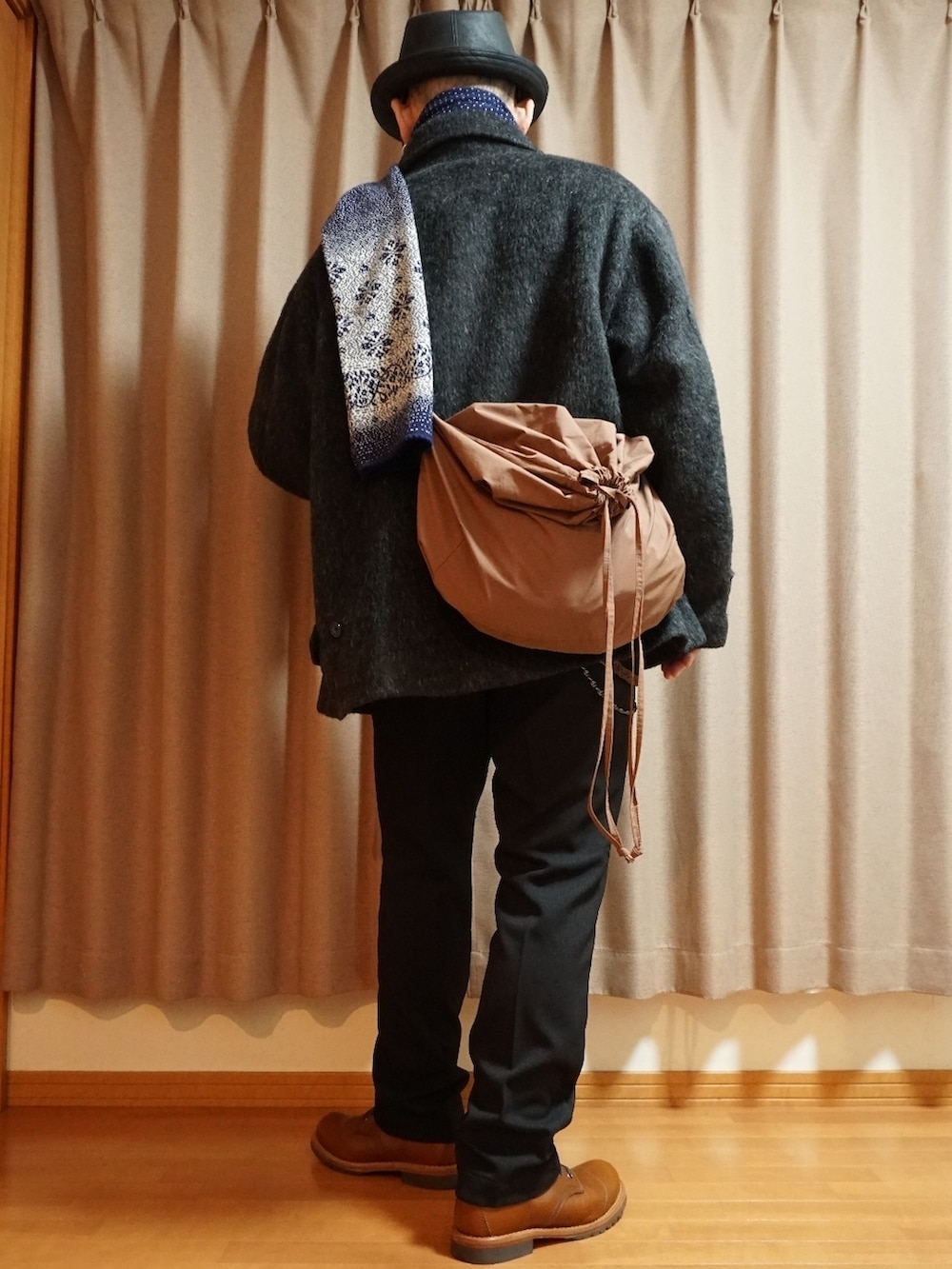 ブラウン系のブーツ、ブラック系のスラックス、ブラック系のトップスを着用したメンズの秋コーディネートの3枚目の写真