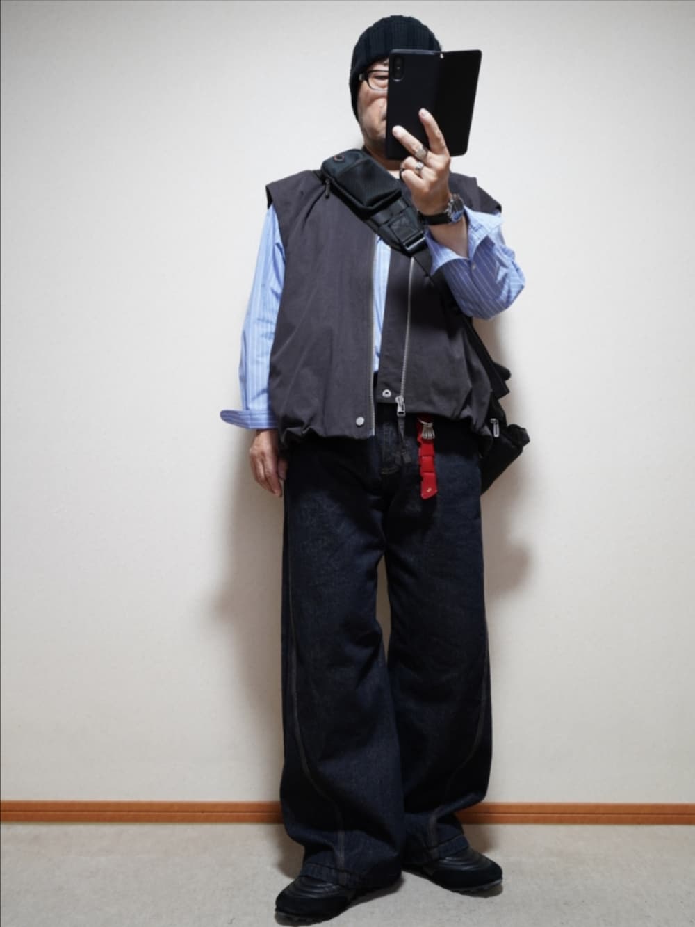 ブラック系のスニーカー、ブルー系のデニムパンツ、ブラウン系のブルゾンを着用したメンズの秋コーディネートの2枚目の写真