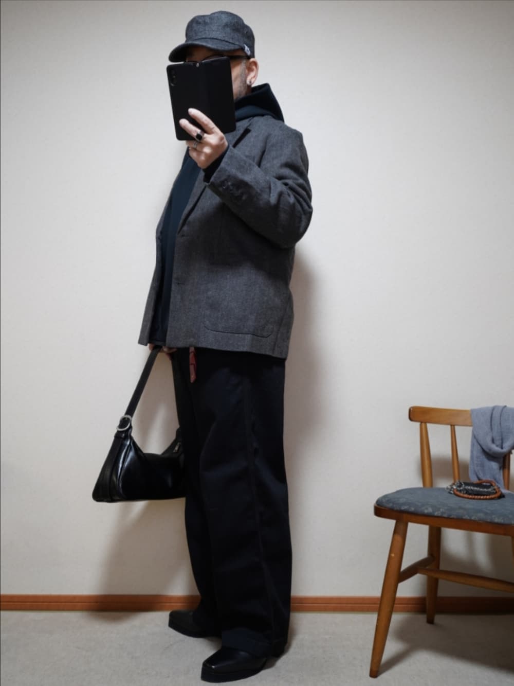 ブラック系のブーツ、ブラック系のデニムパンツ、ブラック系のショルダーバッグを着用したメンズの春コーディネートの2枚目の写真