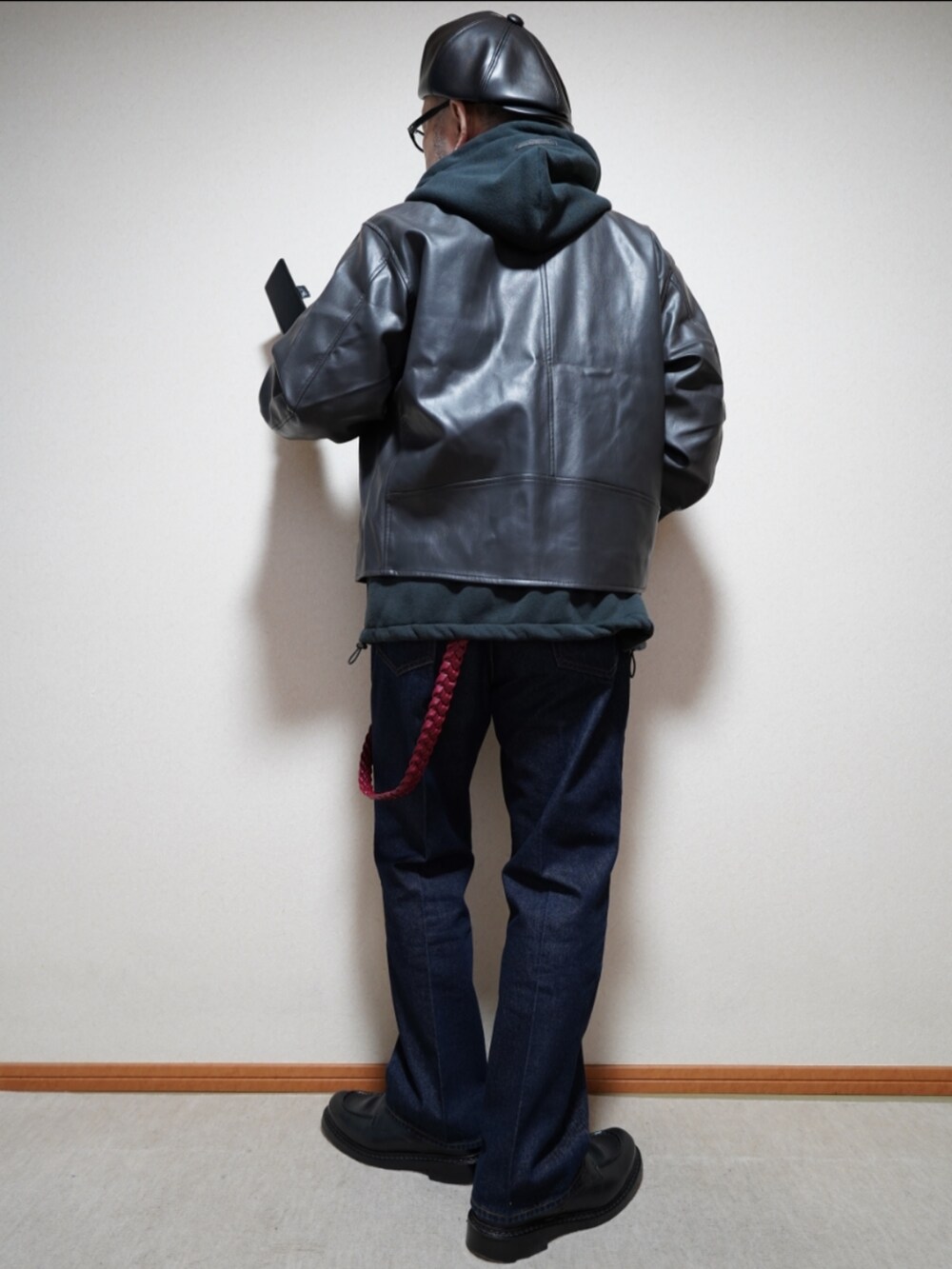 ブラック系のシューズ、ブルー系のデニムパンツ、ブラック系のパーカーを着用したメンズの冬コーディネートの4枚目の写真